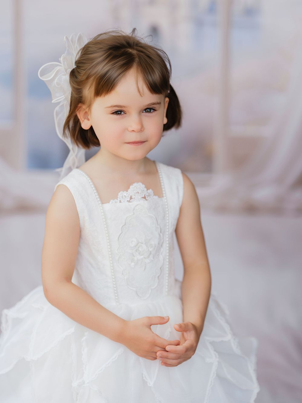A graceful white lace dress with delicate details creates an ethereal and innocent portrait.