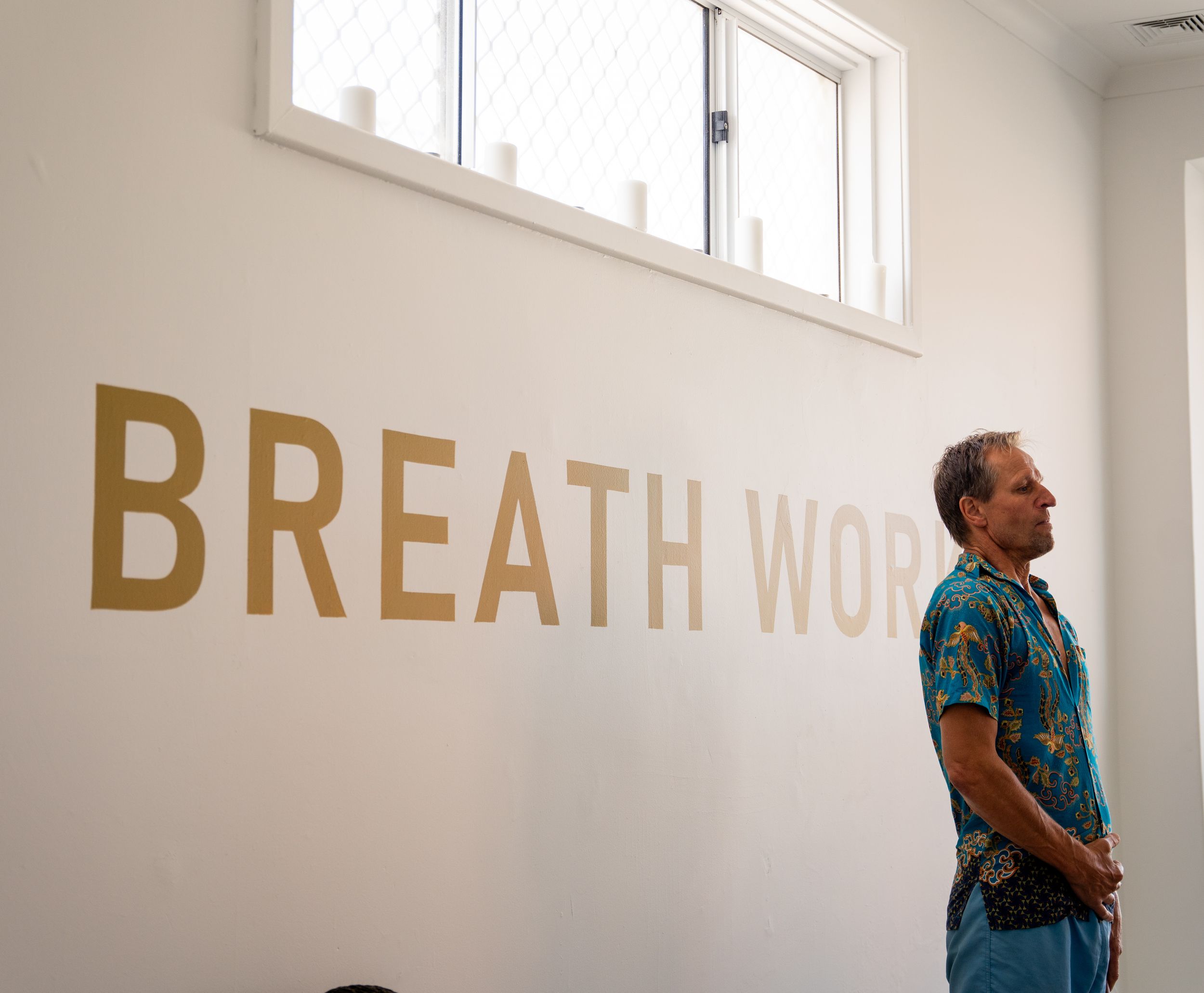 White wall with gold lettering reading 'BREATH' in a modern minimalist space.
