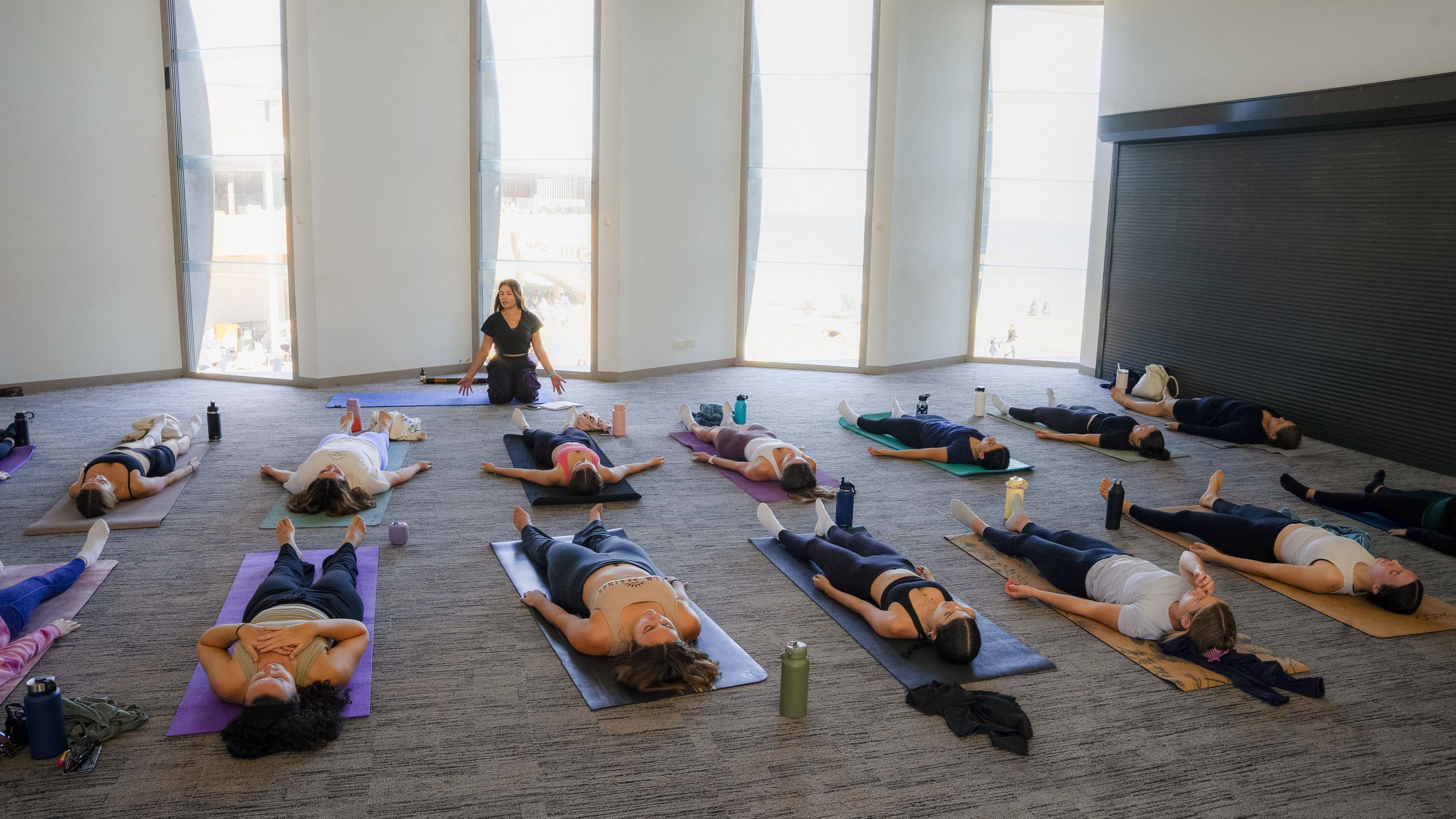 Students practicing yoga poses in a spacious studio with natural light.