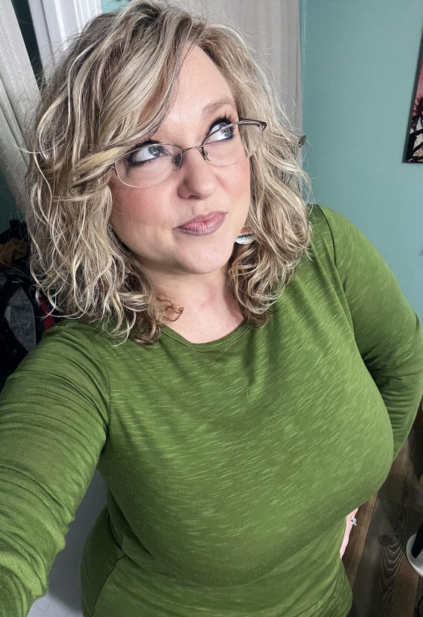 Selfie series in bright green textured sweater against turquoise wall.