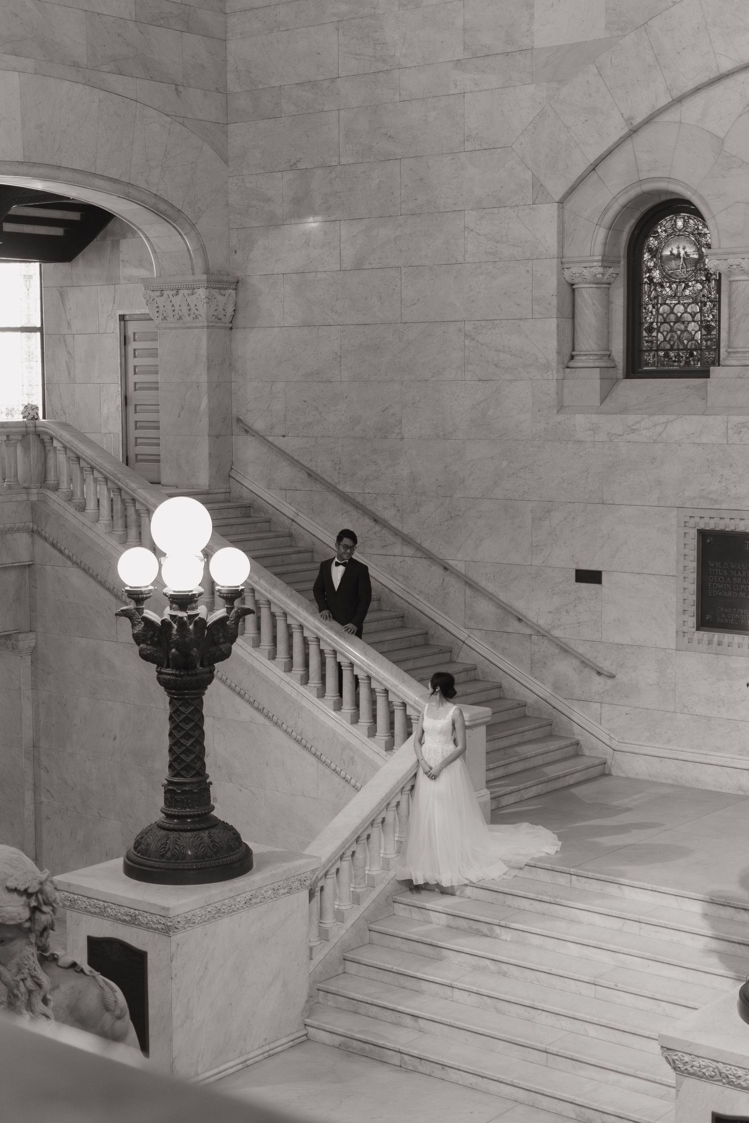 Black and white photo of bride and groom in front of a courthouse for their elopement.