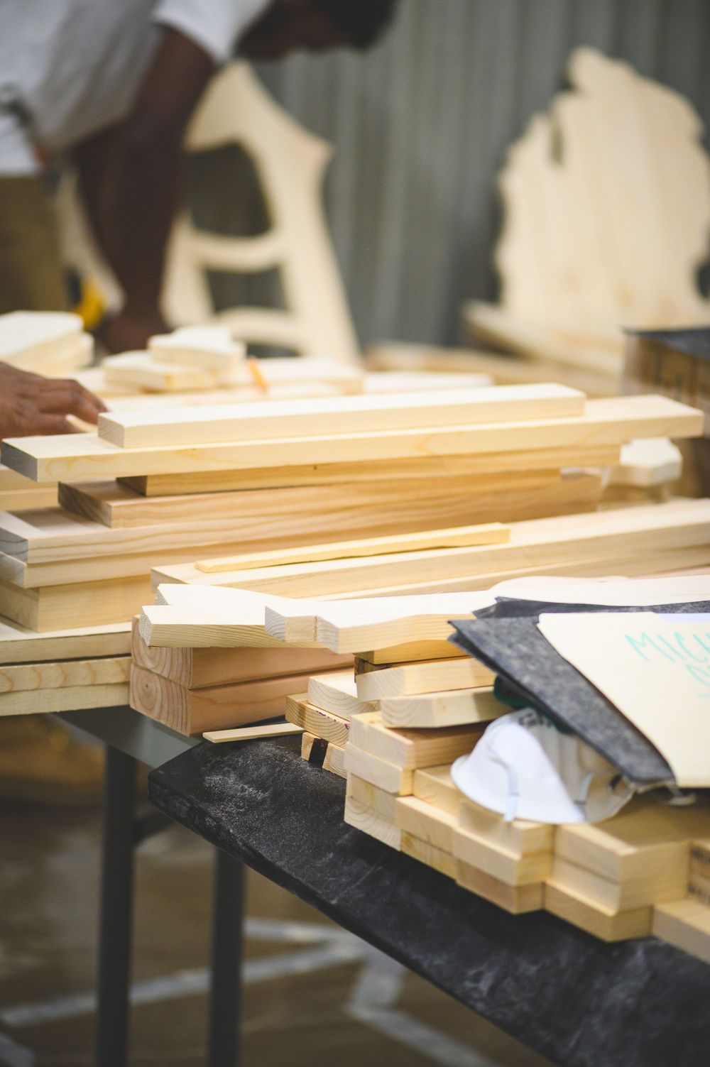 Wooden planks and boards laid out on a dark surface showing carpentry materials ready for woodworking.