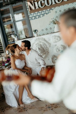 Victor & Regina kissing at her bridal shower , behing the mariachis, playing at Nicoletta Cancun.