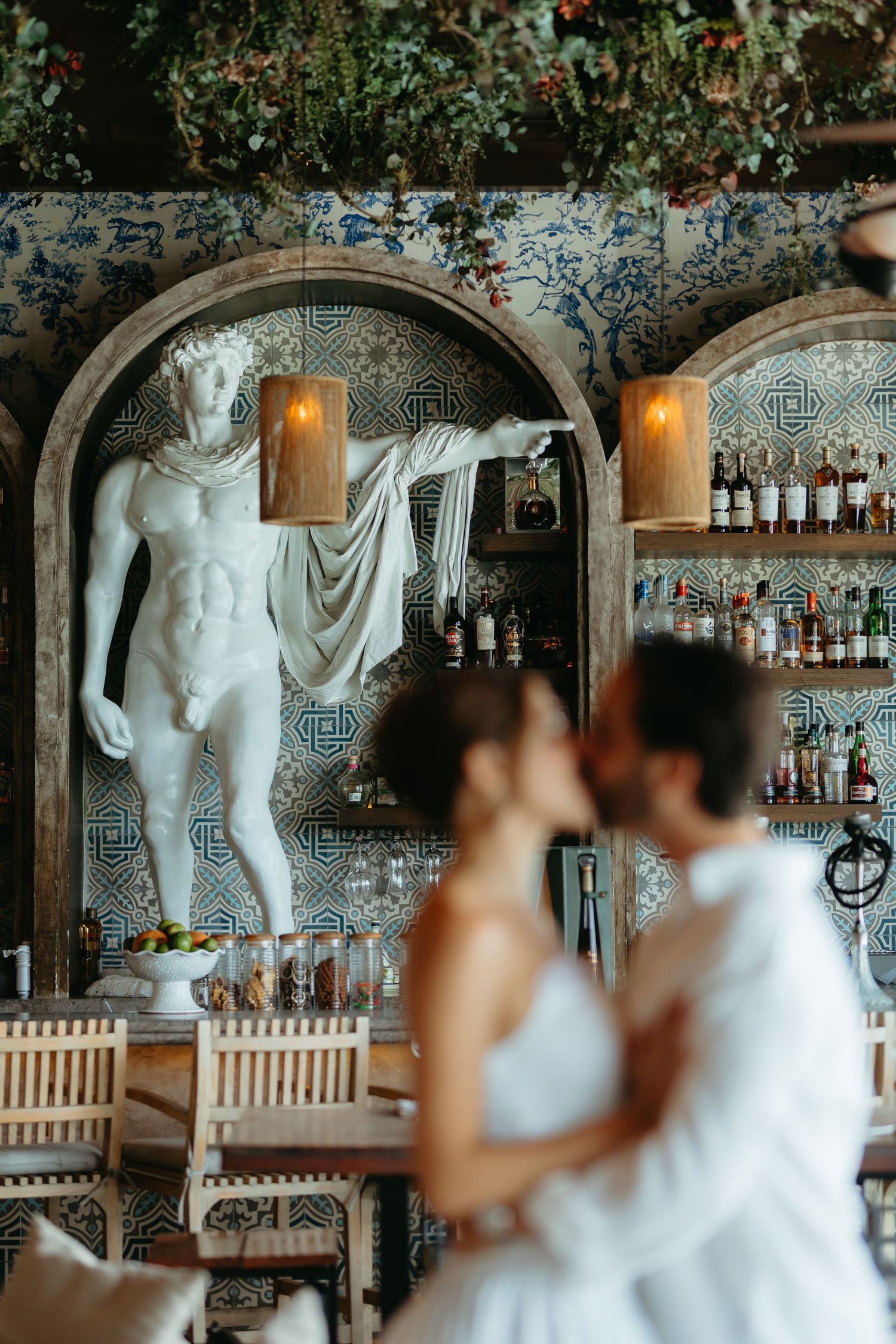 Classic bar interior with ornate white statues and decorative details along the walls and shelves filled with liquor bottles.
Nicoletta