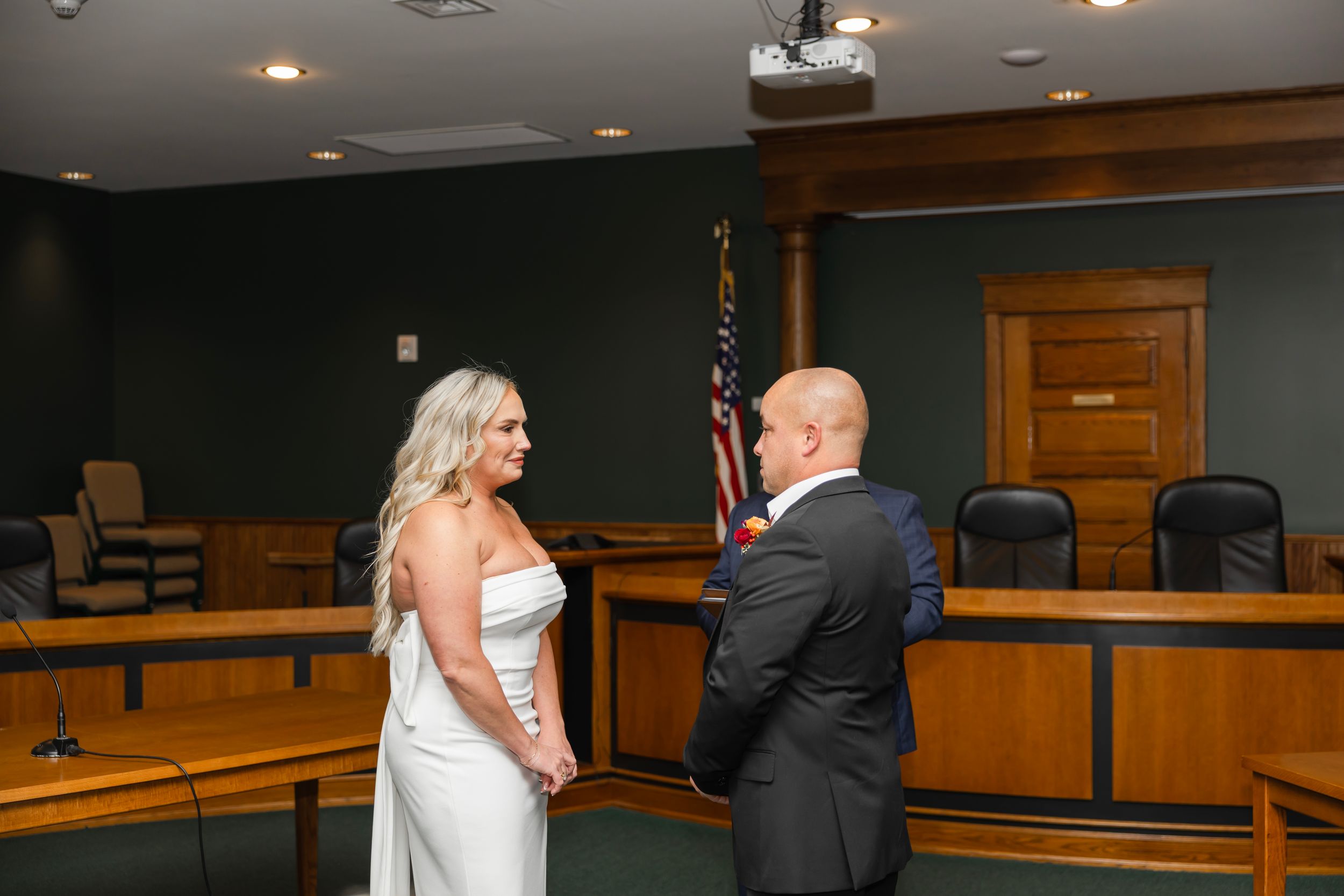 A wedding ceremony takes place in a traditional wooden courtroom - Northern NJ wedding photographer