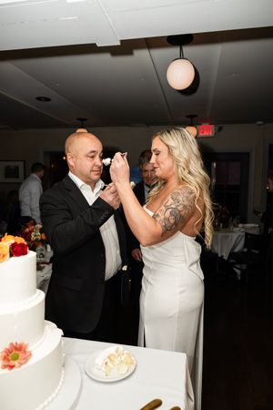 Couple sharing a moment while cutting their wedding cake during the reception celebration. Northern NJ wedding photographer