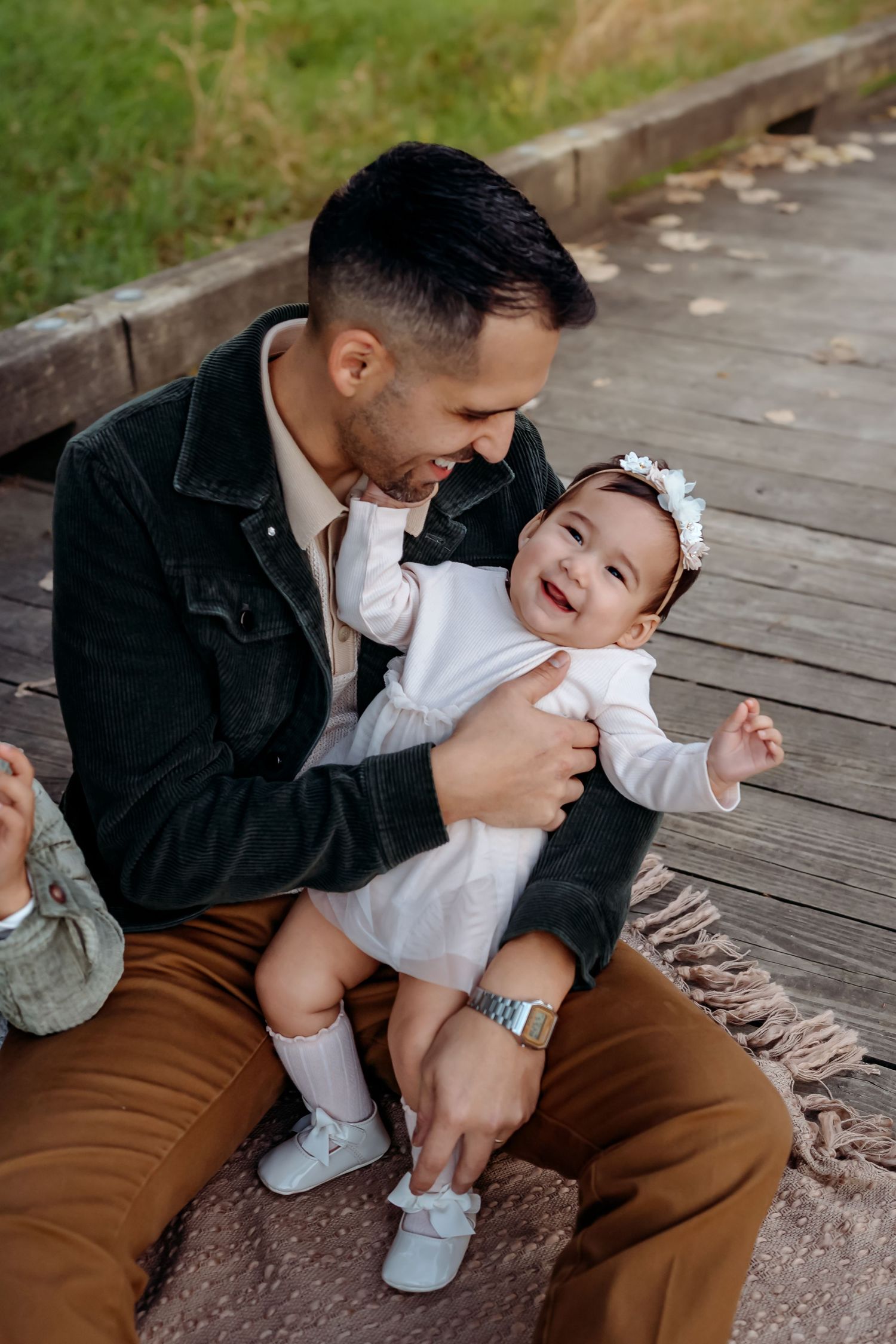 A series of candid moments showing tender interaction between parent and baby on wooden decking outdoors.