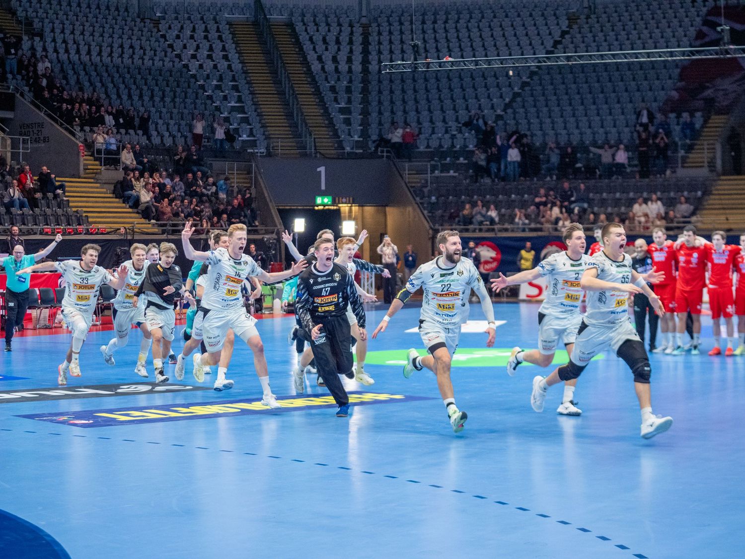 Runar-spillere løper over banen mot publikum i jubel etter seier i NM-finalen i håndball.