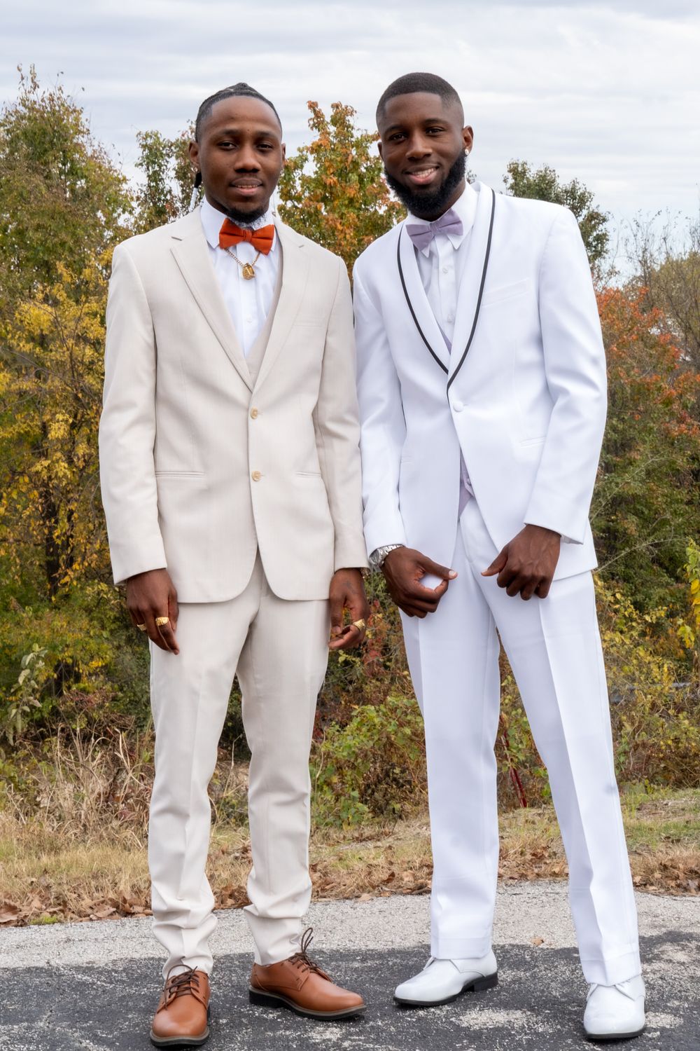 Groom and groomsmen smiling at the camera outside.