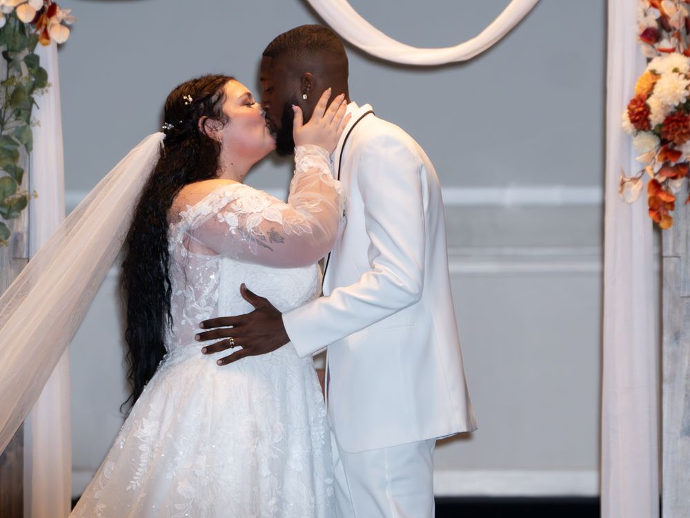Bride and groom kissing each other at their wedding.