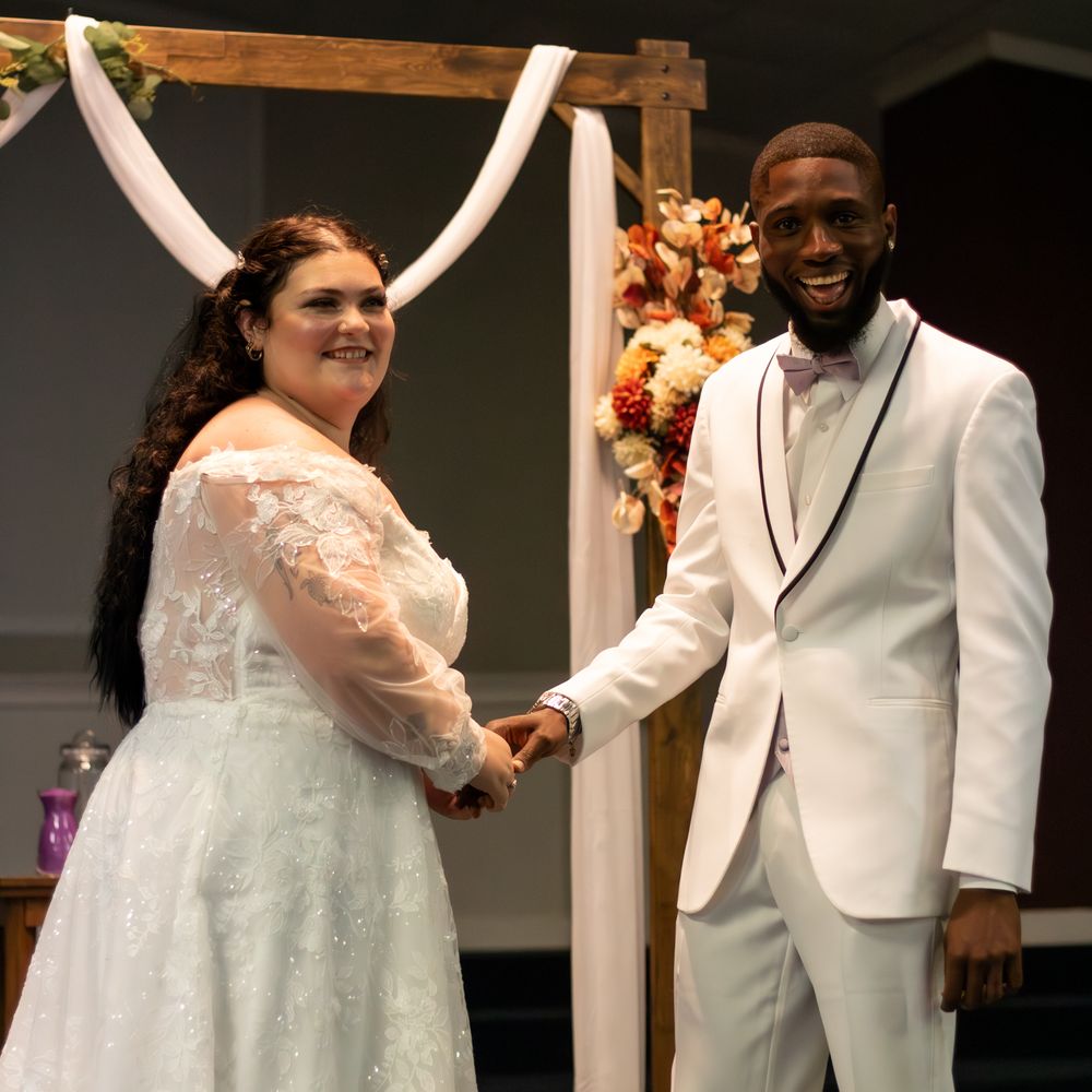 Bride and groom smiling at the camera for their first look pictutres.