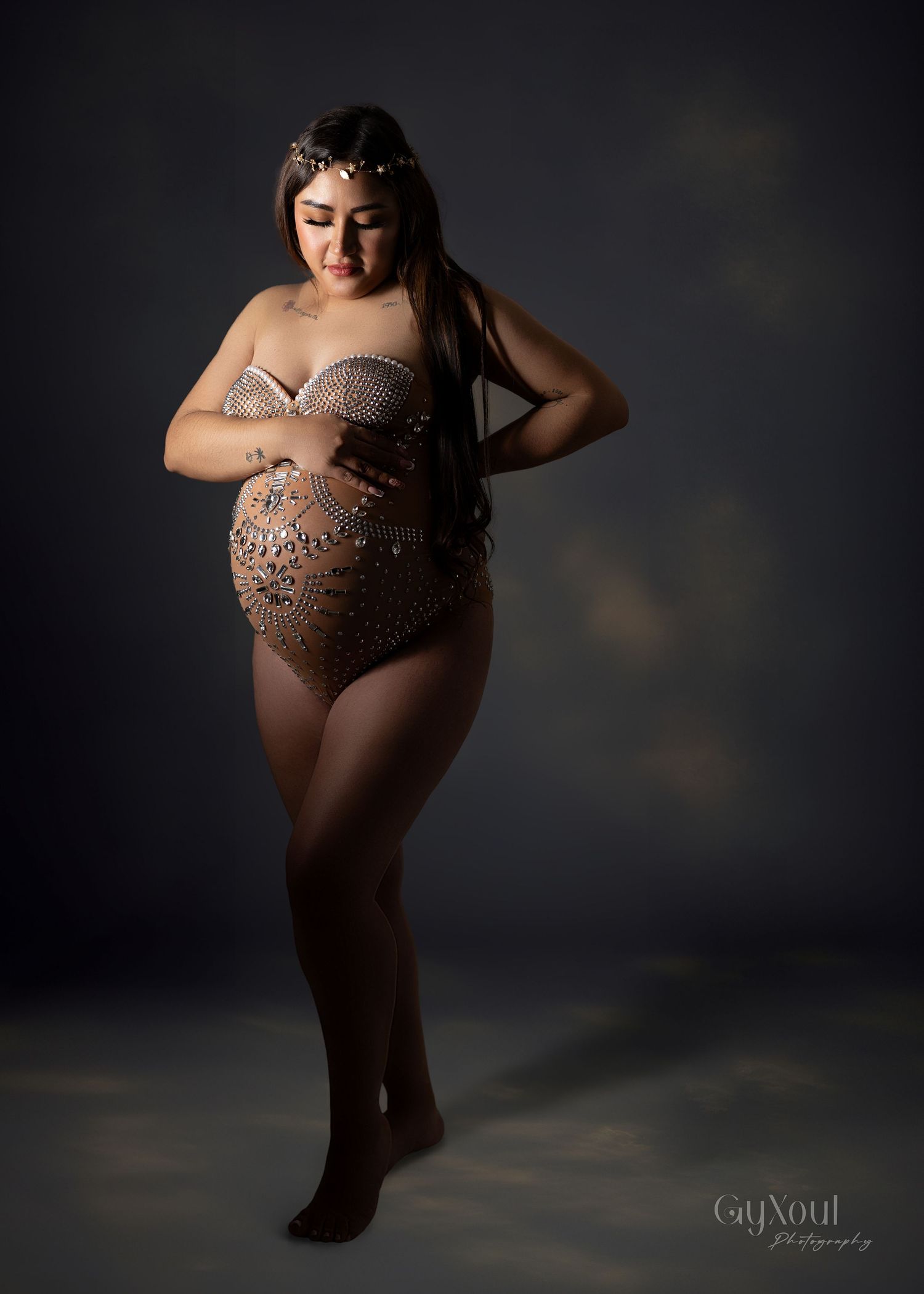 Artistic boudoir photography series featuring dramatic lighting and poses against a dark studio backdrop.