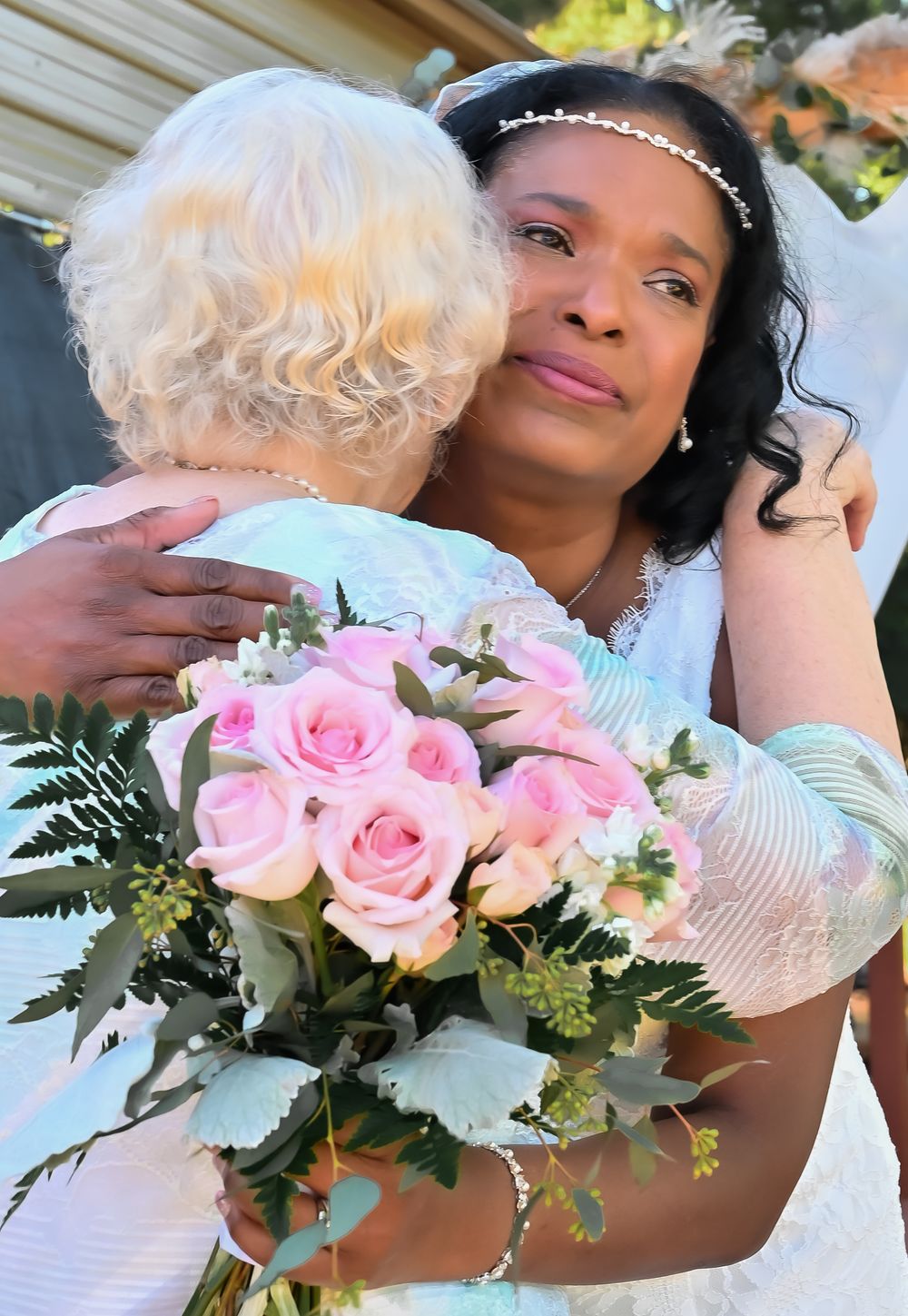 A romantic wedding photoshoot features pink roses and white flowers in an elegant bouquet arrangement.