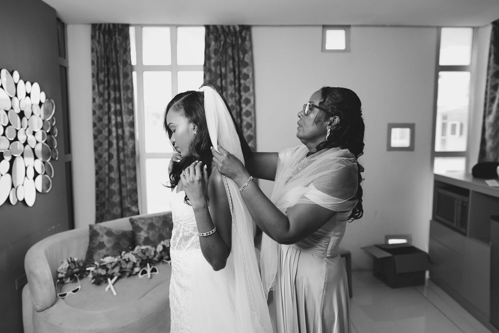 A black and white photo collage showing intimate moments during a wedding ceremony and preparation.