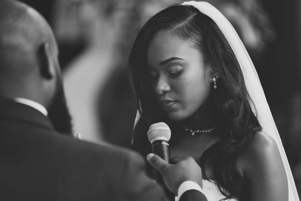A series of black and white photos showing a woman speaking at a microphone in different emotional expressions.