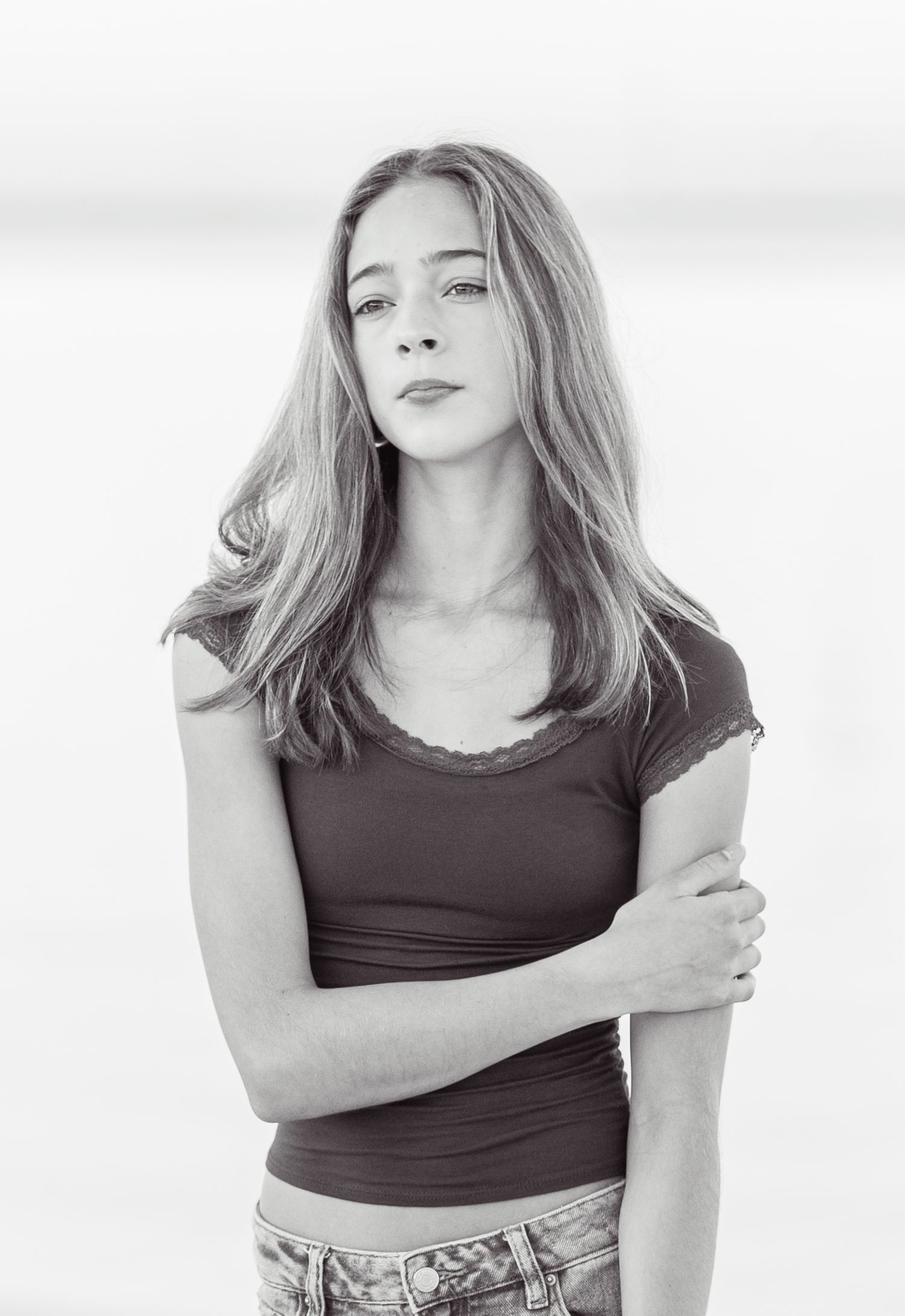A series of black and white fashion portraits showing a person in a dark tank top posing against a light background.