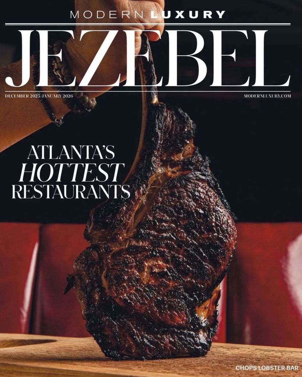 A magazine cover of Jezebel featuring a close-up shot of a charred tomahawk steak on a wooden board.