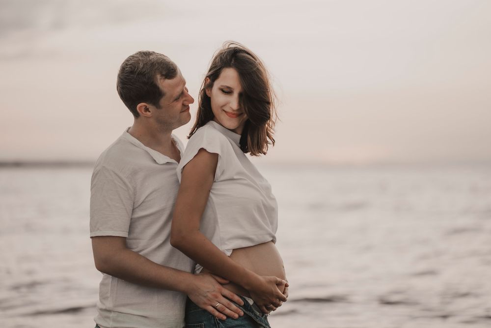 Intimate portrait of an international couple watching the sunset from the sands of Caorle, Italy.