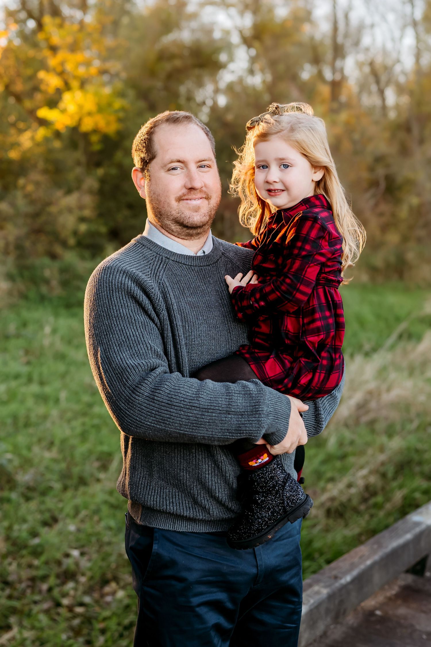 A parent and child share a tender moment together on a wooden walkway during autumn.