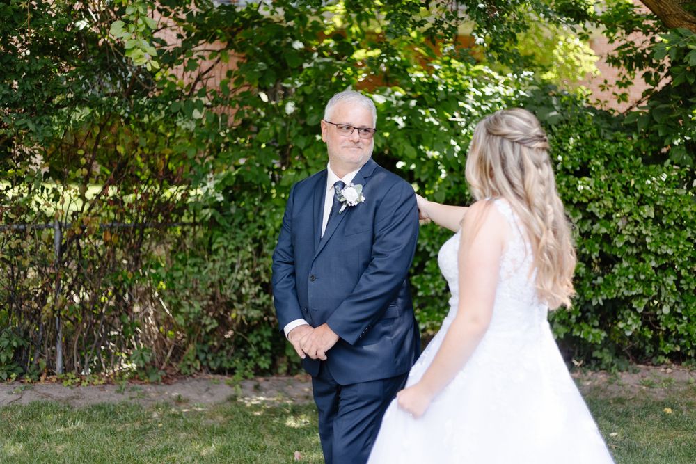 Wedding couple stands in a lush garden setting during an outdoor ceremony.