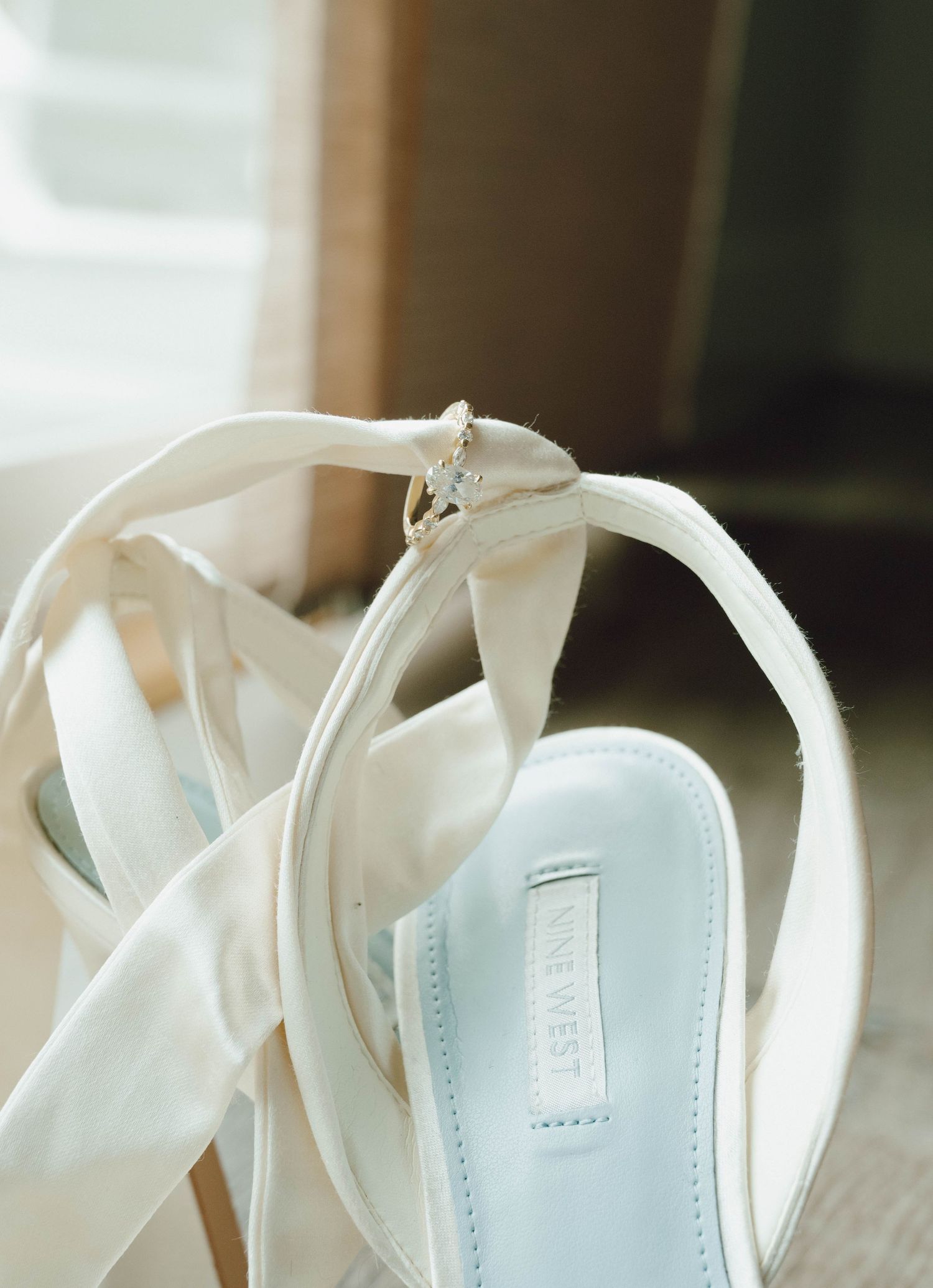 White strappy sandals with block heels and ankle straps displayed in a row against a light background.