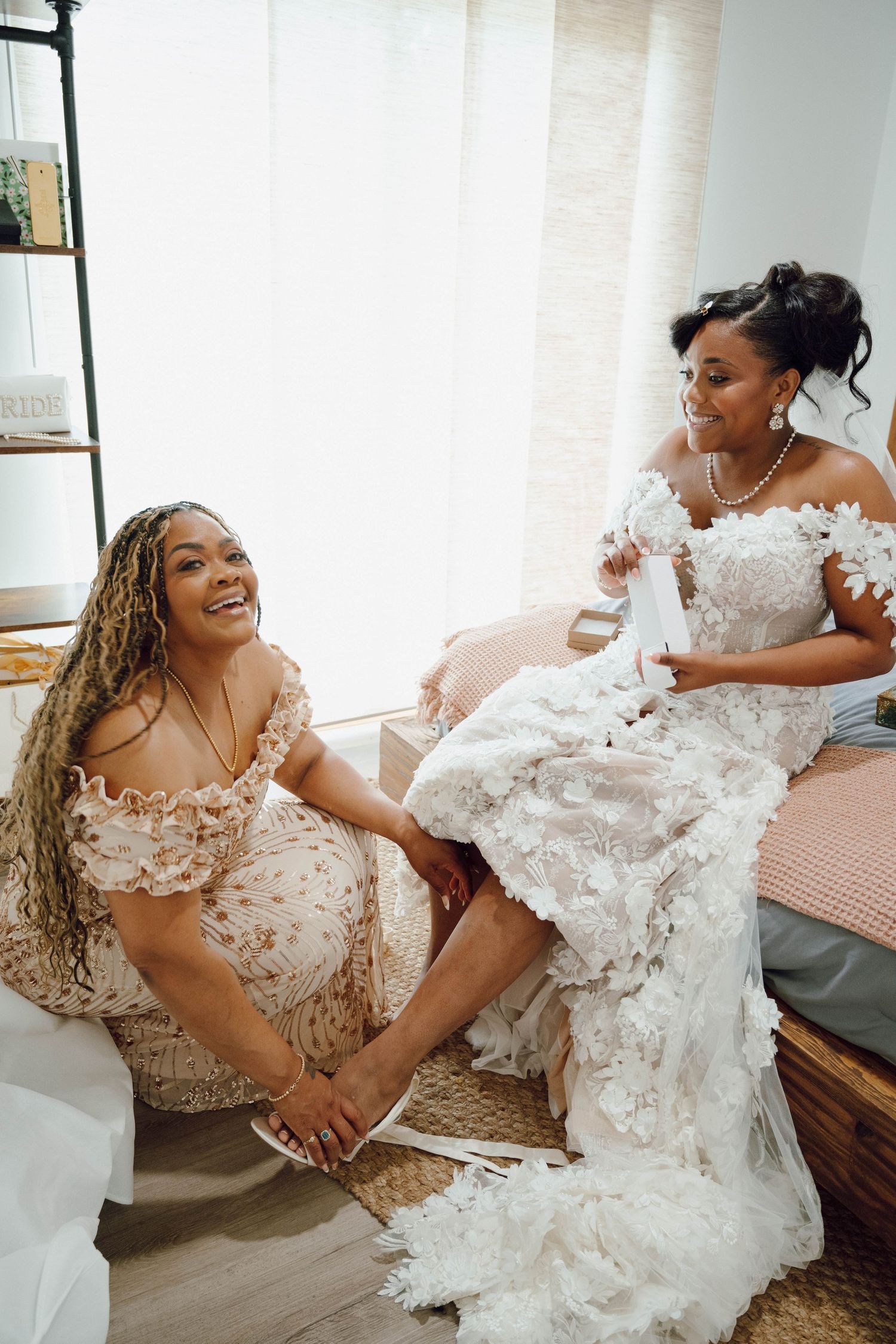 Joyful moments captured of someone in an elegant lace wedding dress relaxing on a couch.