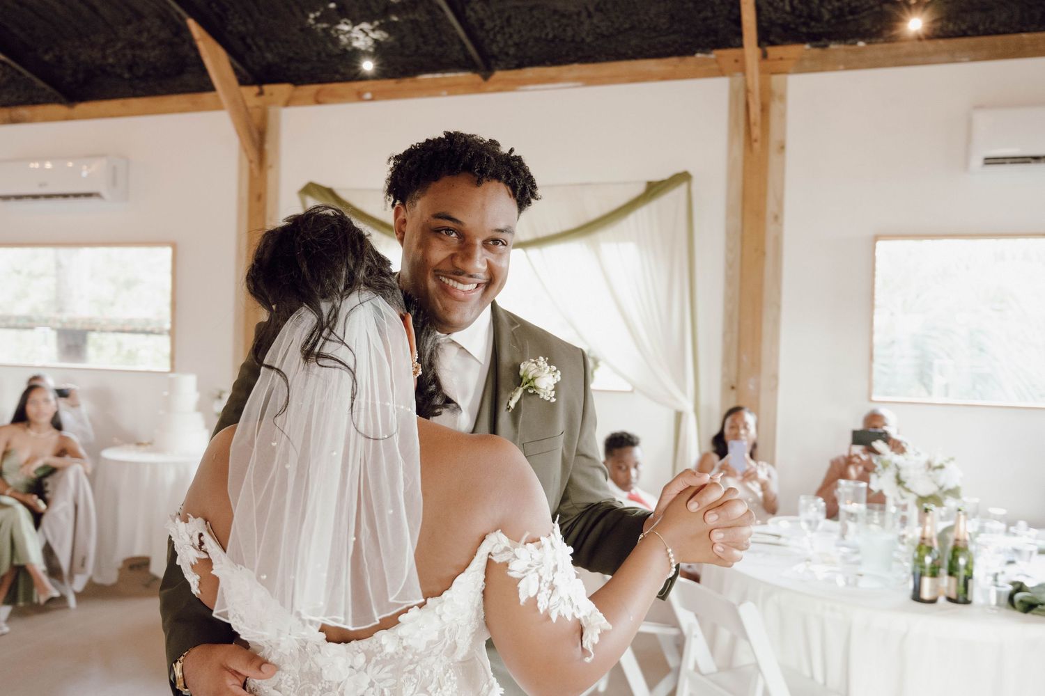 Wedding celebration candid moments captured inside a rustic barn venue with string lights.