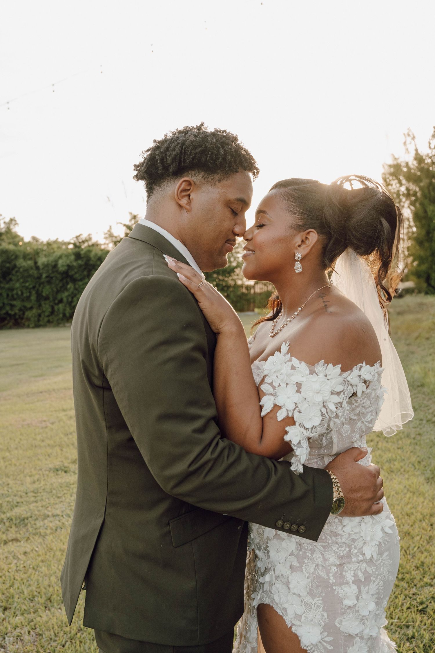 Intimate wedding portrait captured during golden hour in an outdoor garden setting.