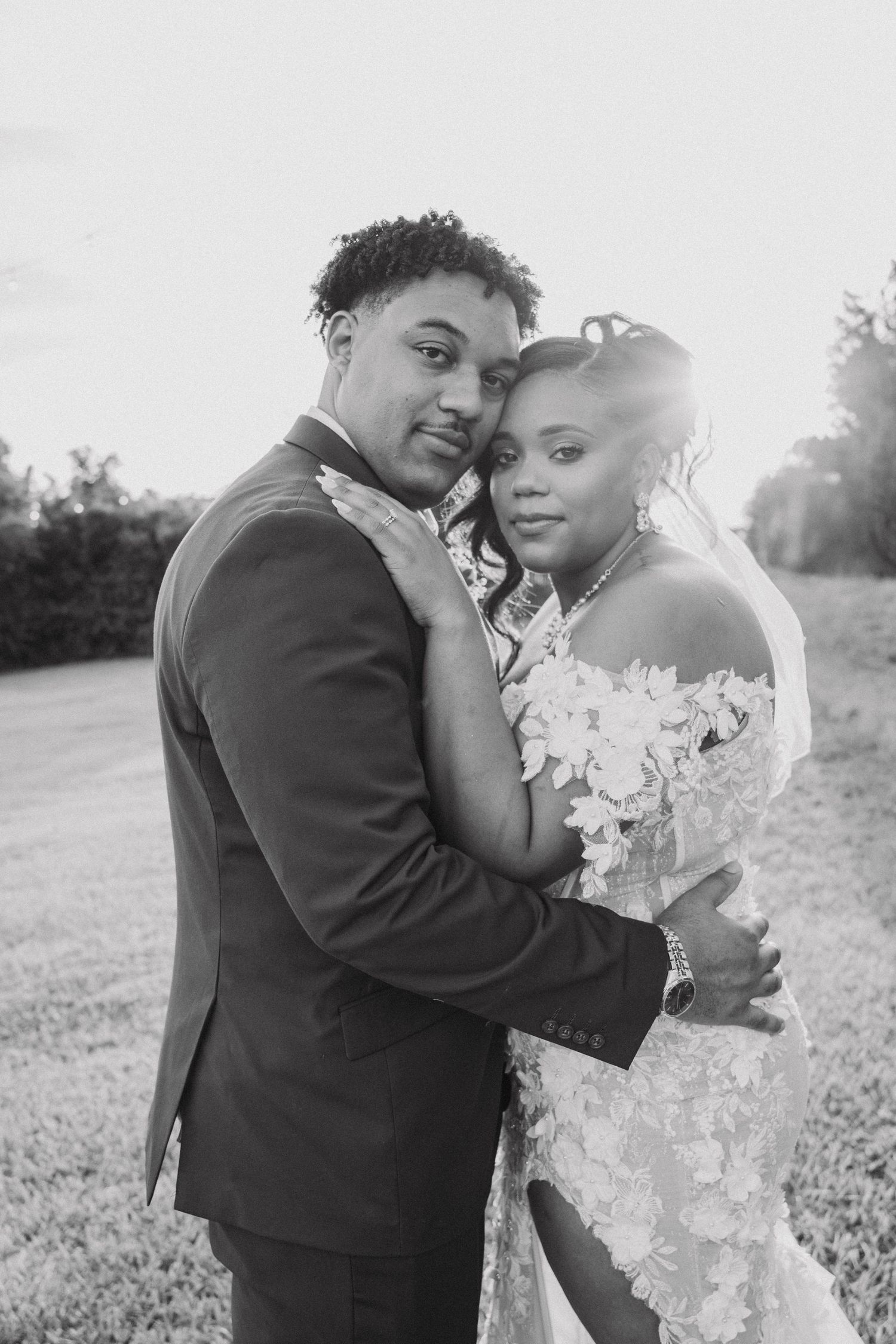 Romantic sunset wedding portraits show tender moments between newlyweds in an open field.