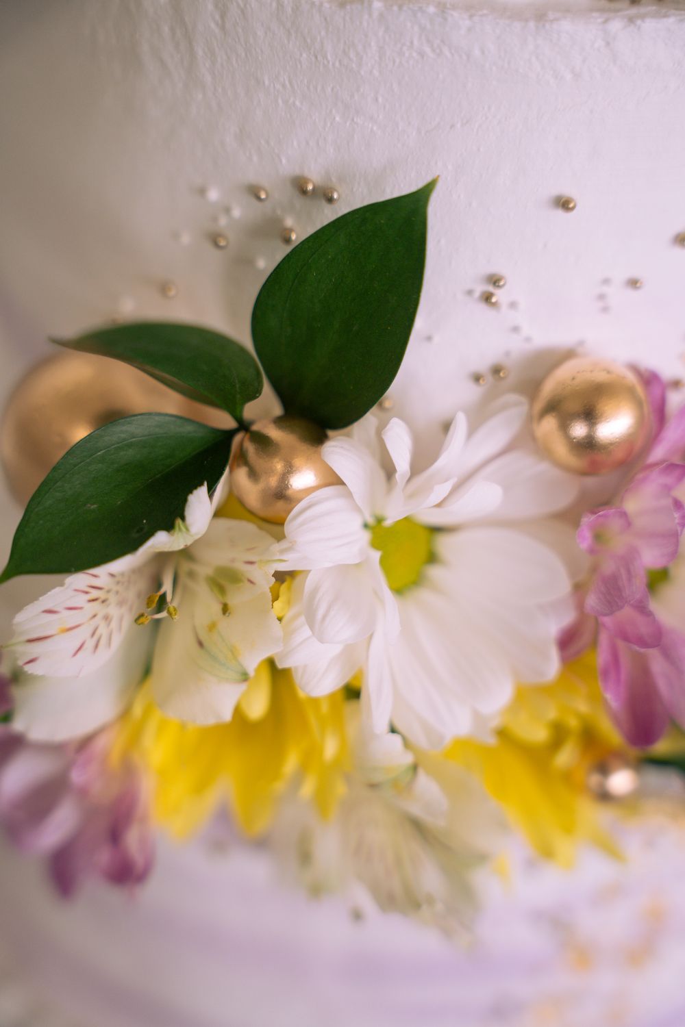 White alstroemeria flowers with yellow centers and green leaves arranged in a soft, dreamy composition.
