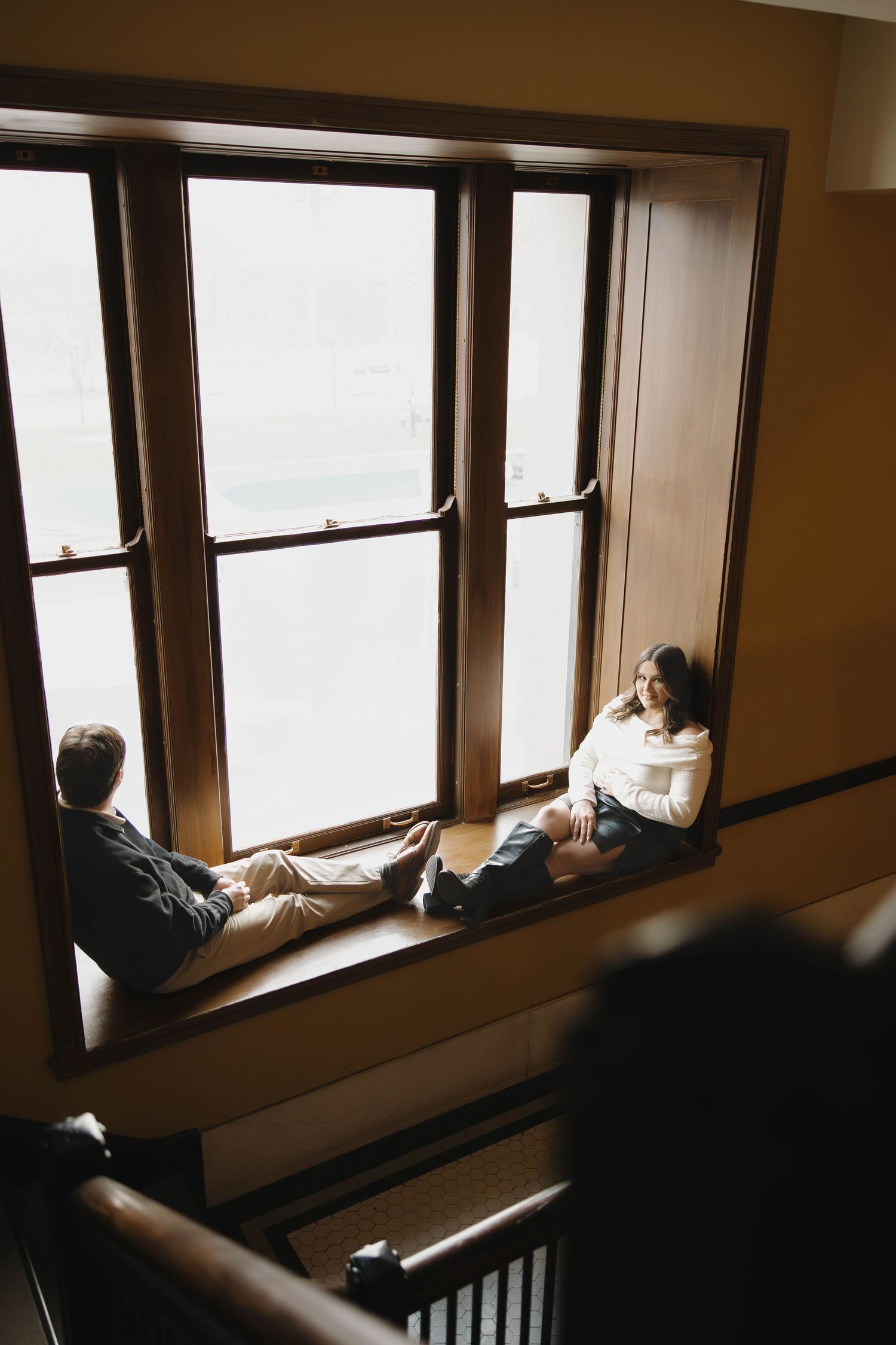 A series of window seats in a train or boat with natural light streaming in through the windows.