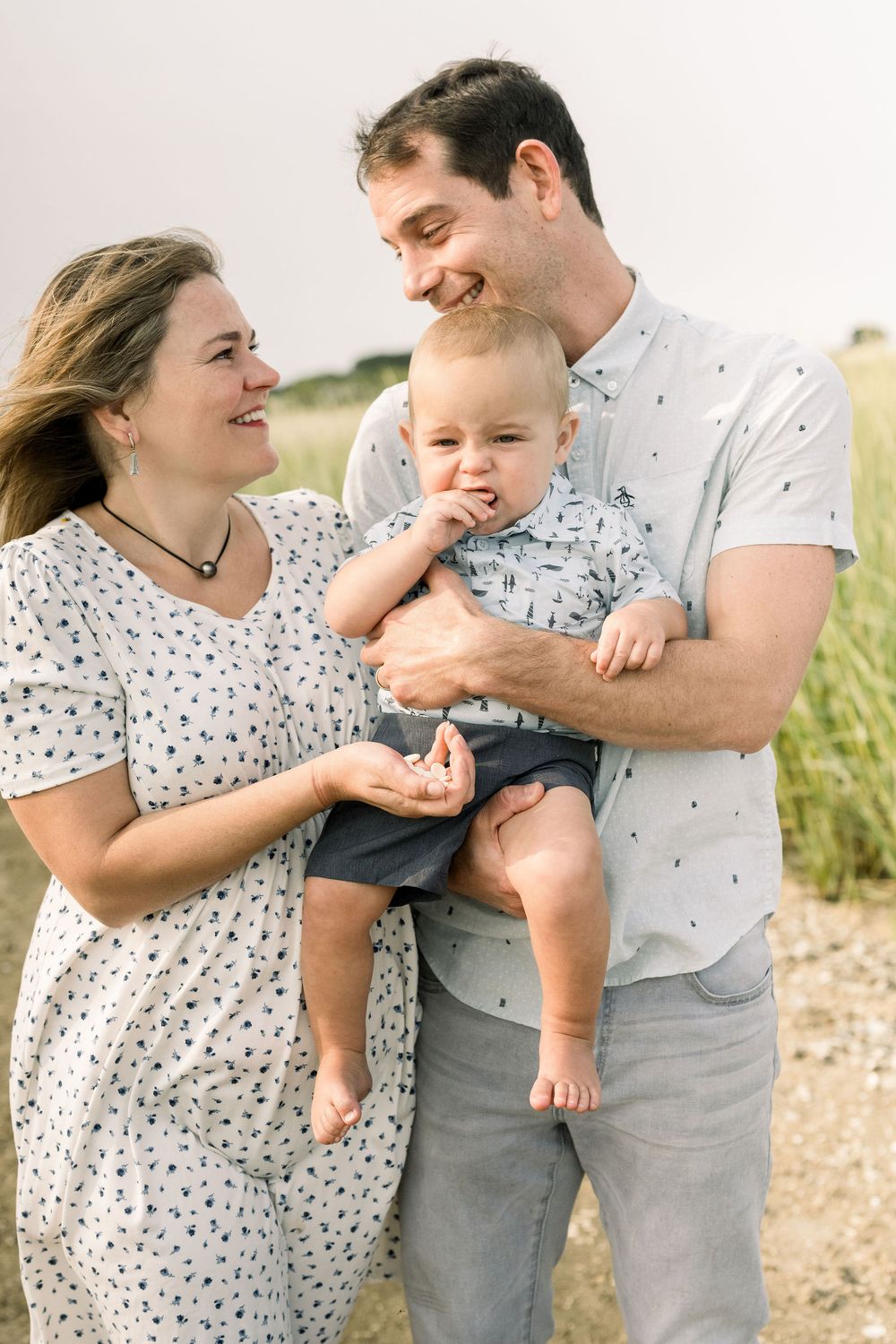 A happy family shares a joyful moment together outdoors on a sunny day.