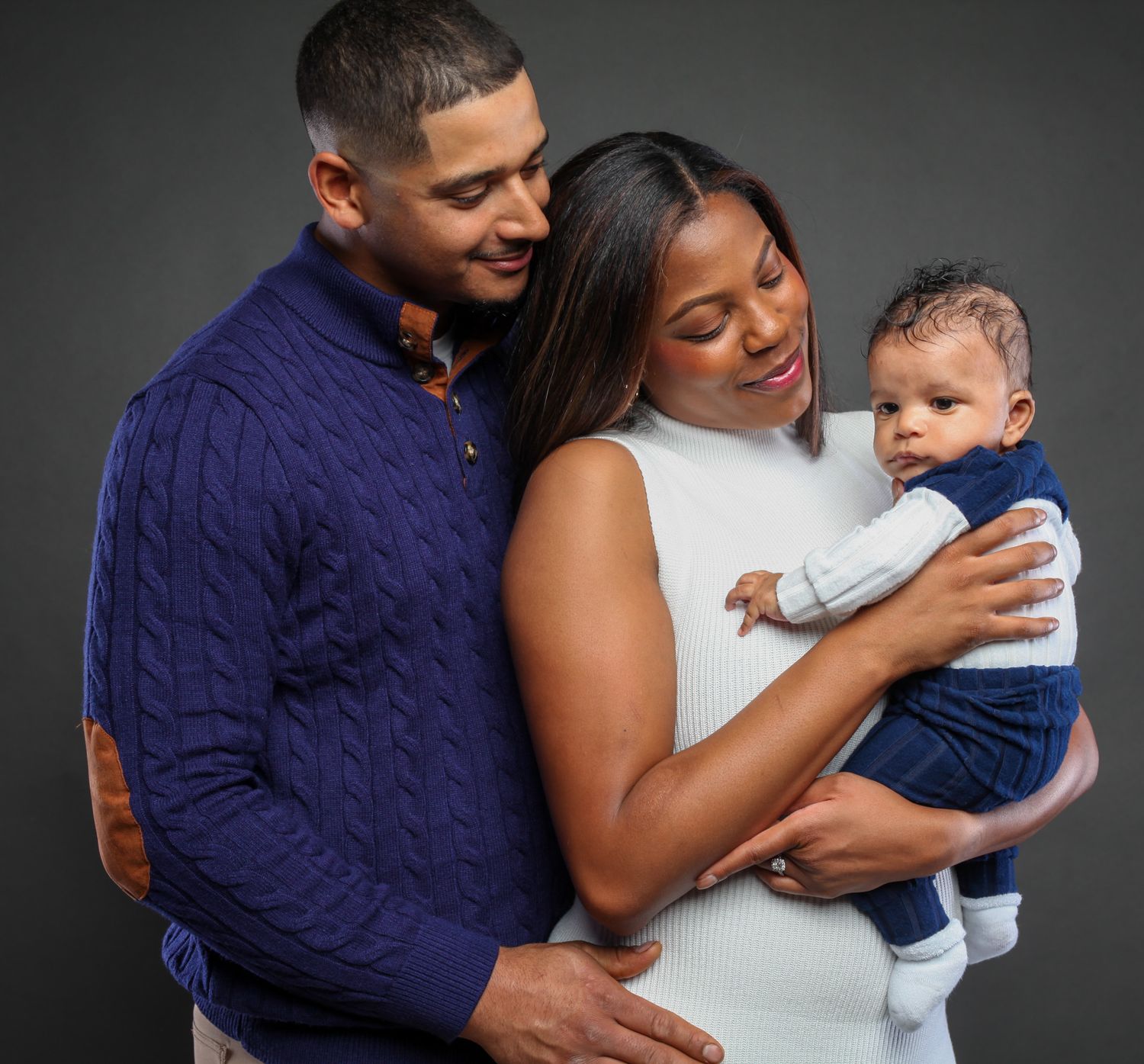 A series of tender moments between parents and their baby, showing loving embraces against a dark background.