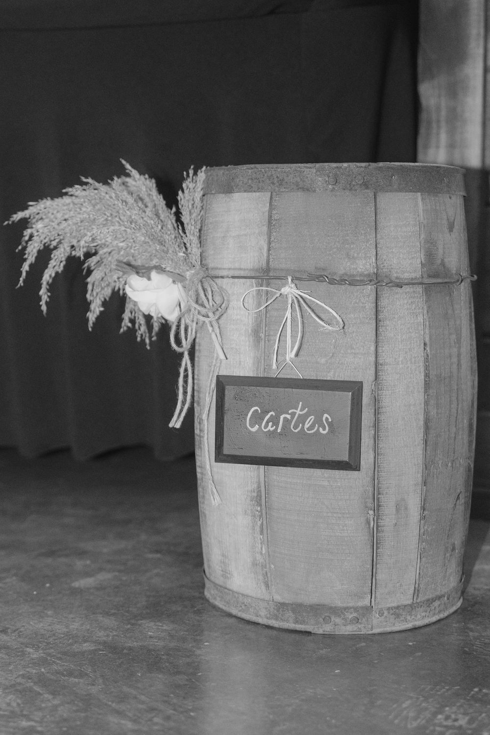 Black and white photo of vintage wooden barrels with cards sign.