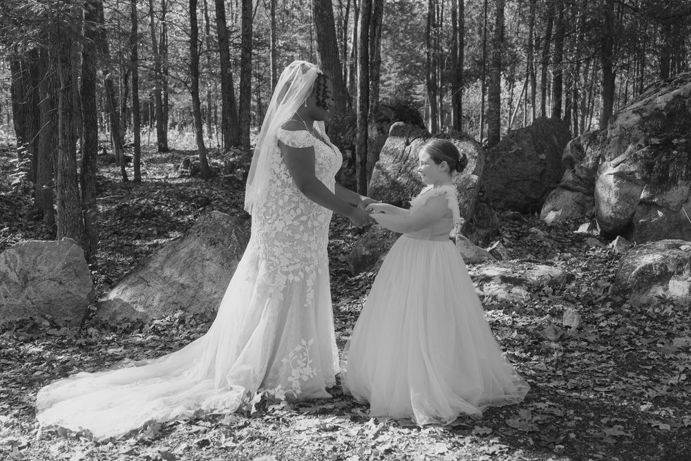 Wedding party posing among trees in a serene woodland setting during autumn.