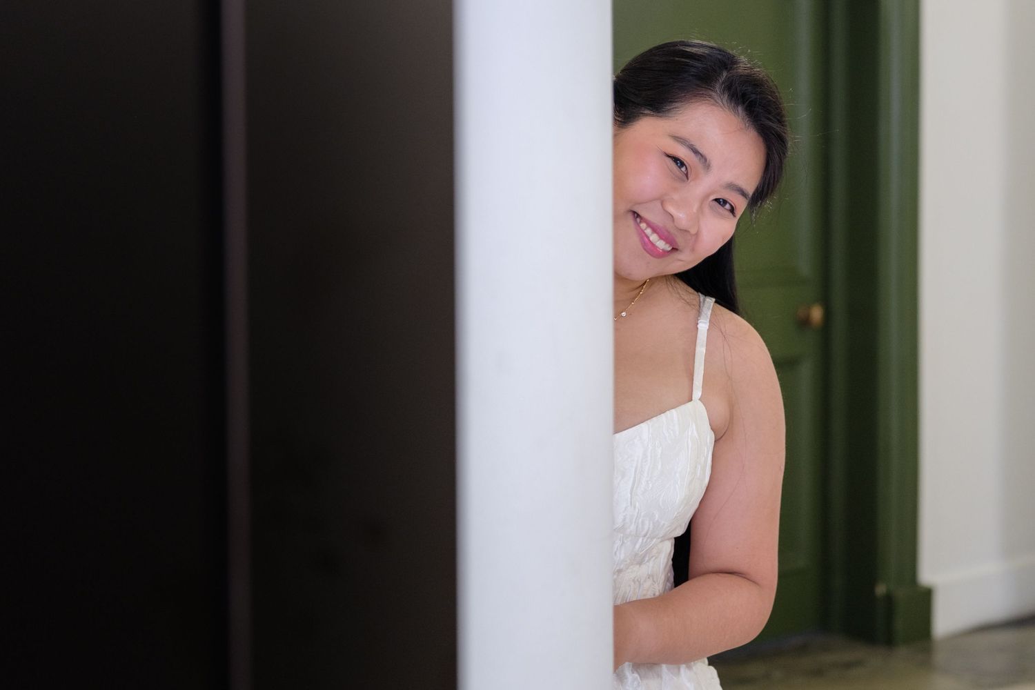 A series of candid portrait shots showing someone in a white dress posing playfully against a dark background.