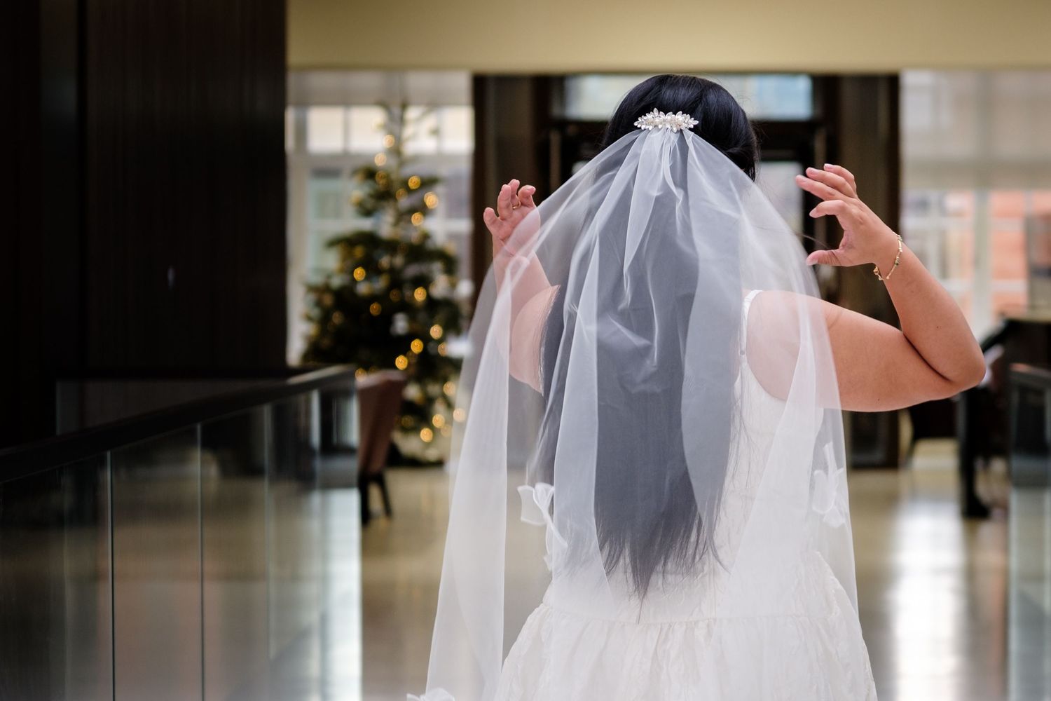 A bride in a white wedding dress and veil is shown in a series of photos walking through an elegant interior space.
