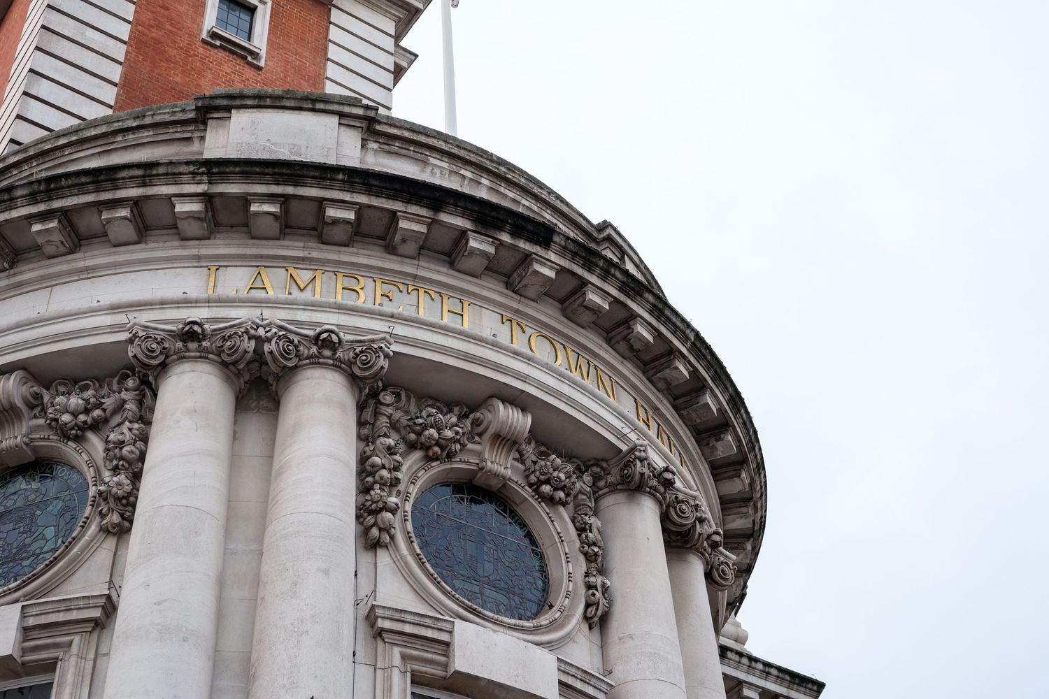 Architectural details of St Paul's Cathedral in London showing ornate stone columns and decorative elements against blue sky.