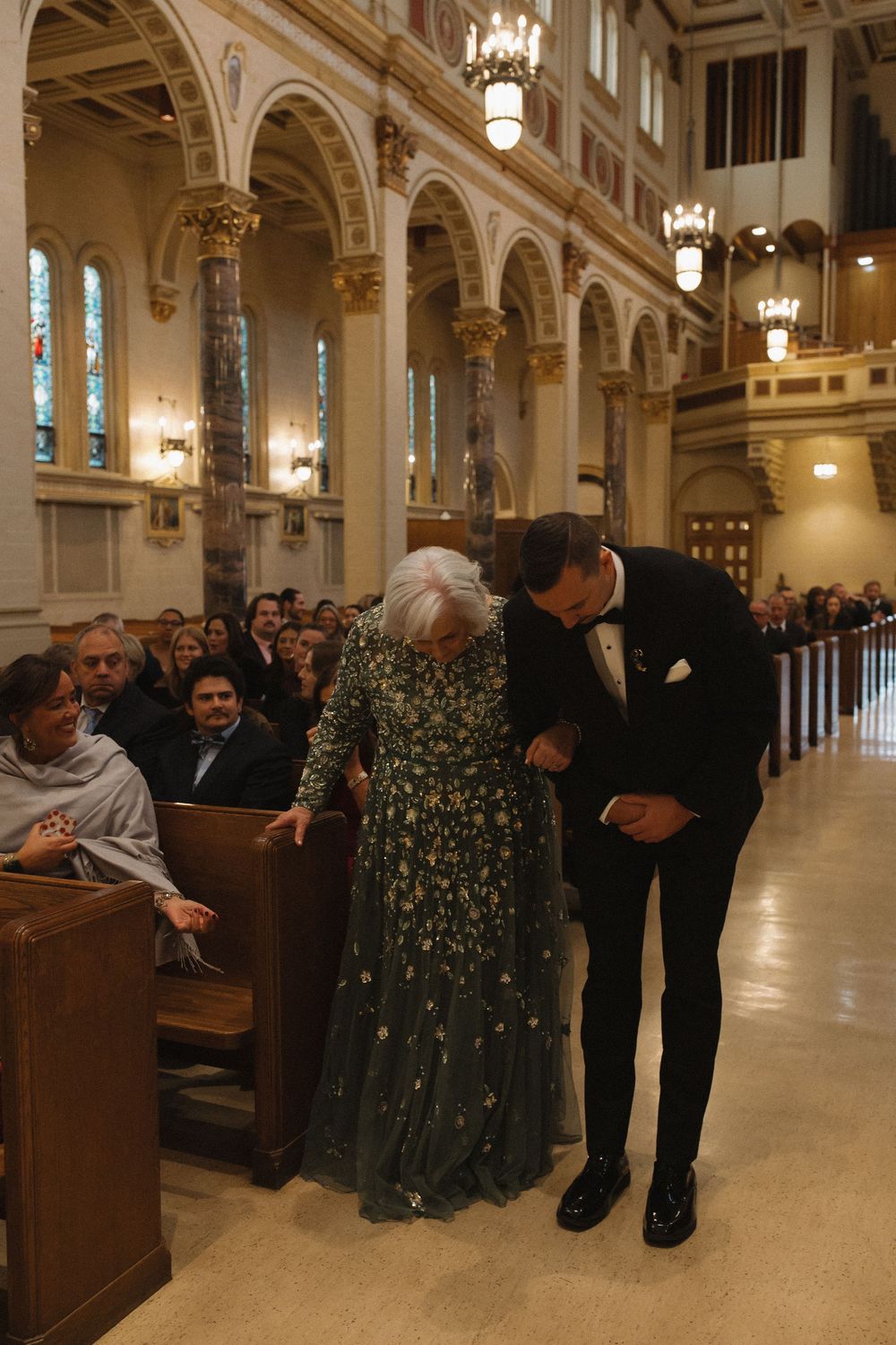 Wedding guests and attendees gathered in the church aisle and pews.