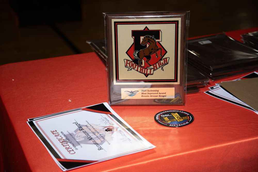 A dark red table surface with papers and documents scattered across it in low lighting conditions.