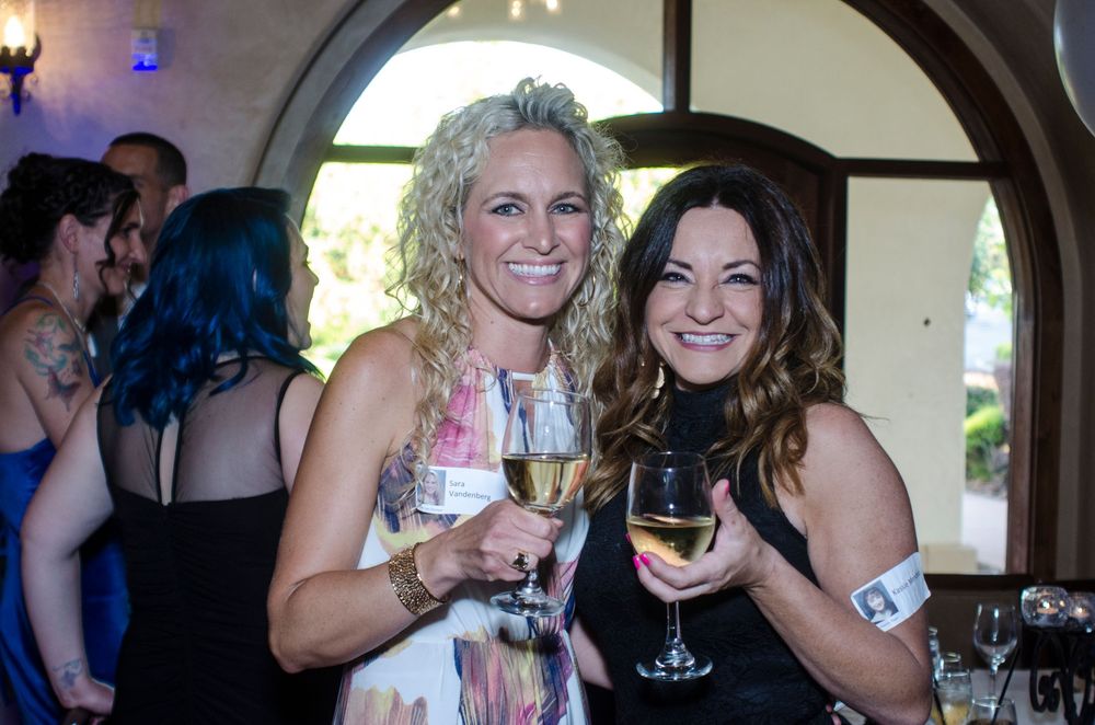 A group of people holding wine glasses and celebrating at what appears to be a social gathering or party.
