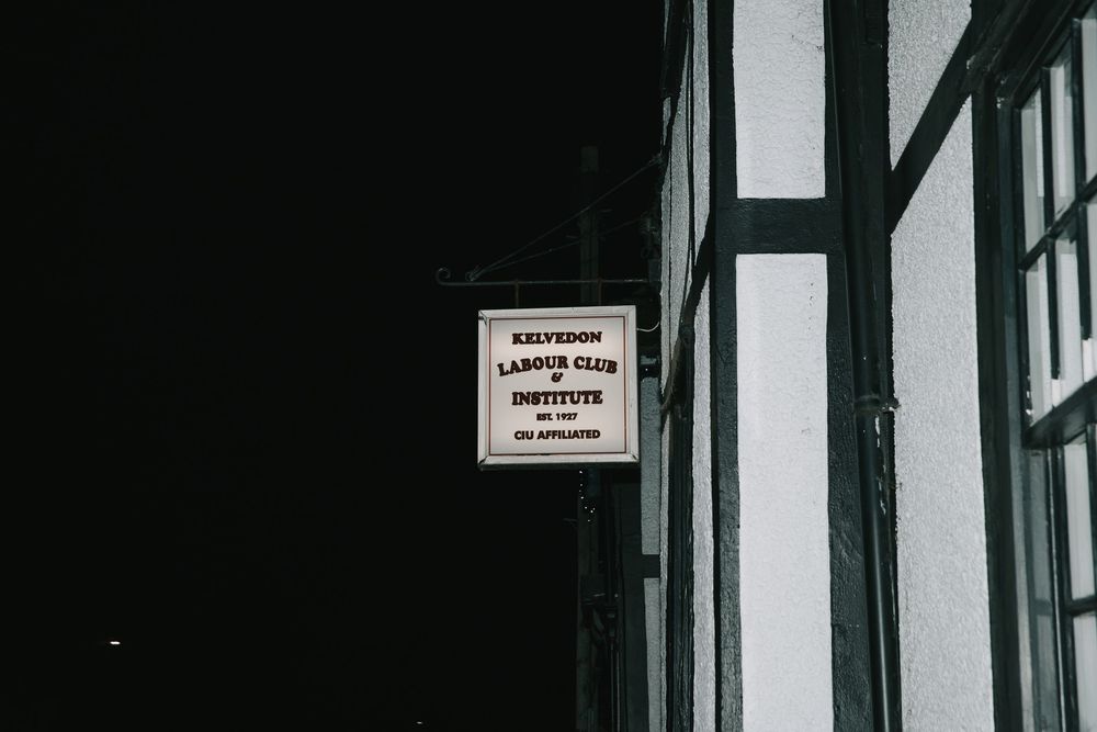 A black and white interior hallway with windows and a sign mounted on the wall.