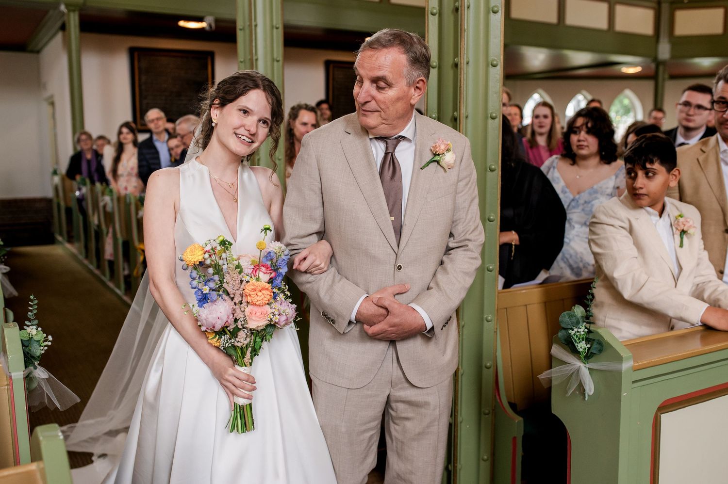 Bruid straalt in witte jurk tijdens aankleden, gefotografeerd door christelijke trouwfotograaf