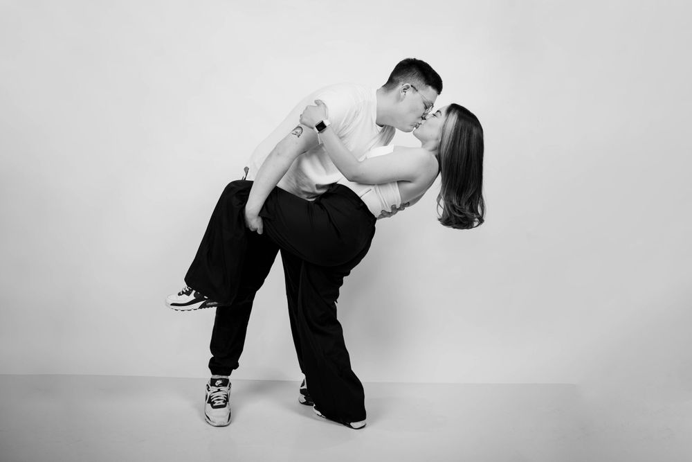 A dynamic studio photo showing a romantic dip pose in black and white.