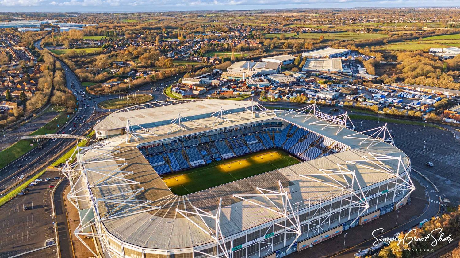 Aerial view of the Coventry Building Society Arena stadium (Home of Coventry City F.C.) near a busy roundabout during autumn.