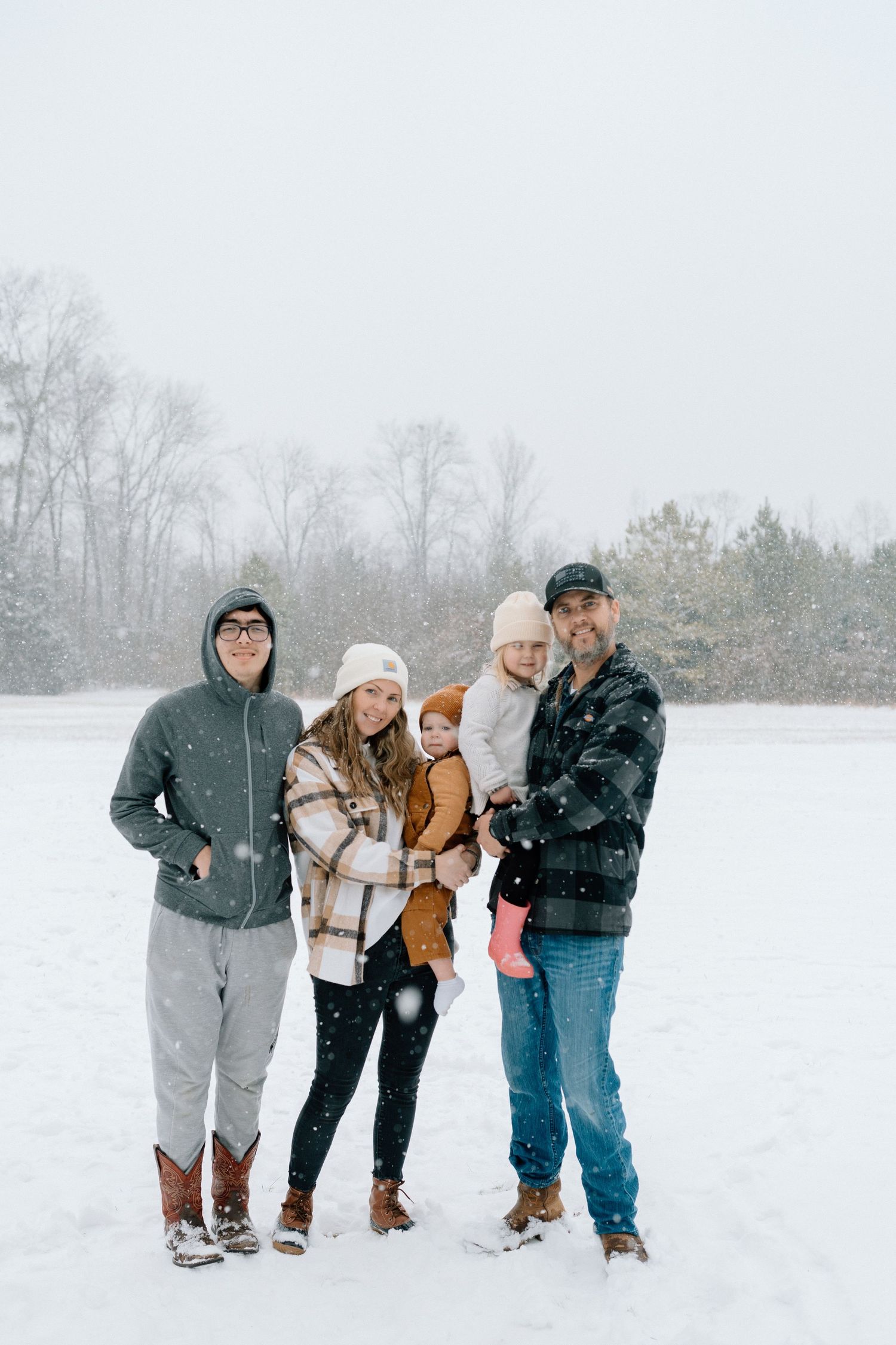 Group walking together through a snowy field during winter while wearing warm coats and boots Chattanooga Family