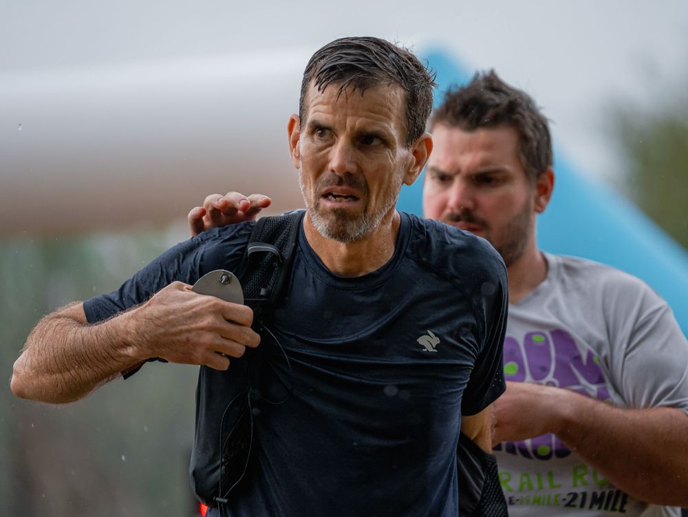 Athletes competing in a rainy outdoor sporting event.