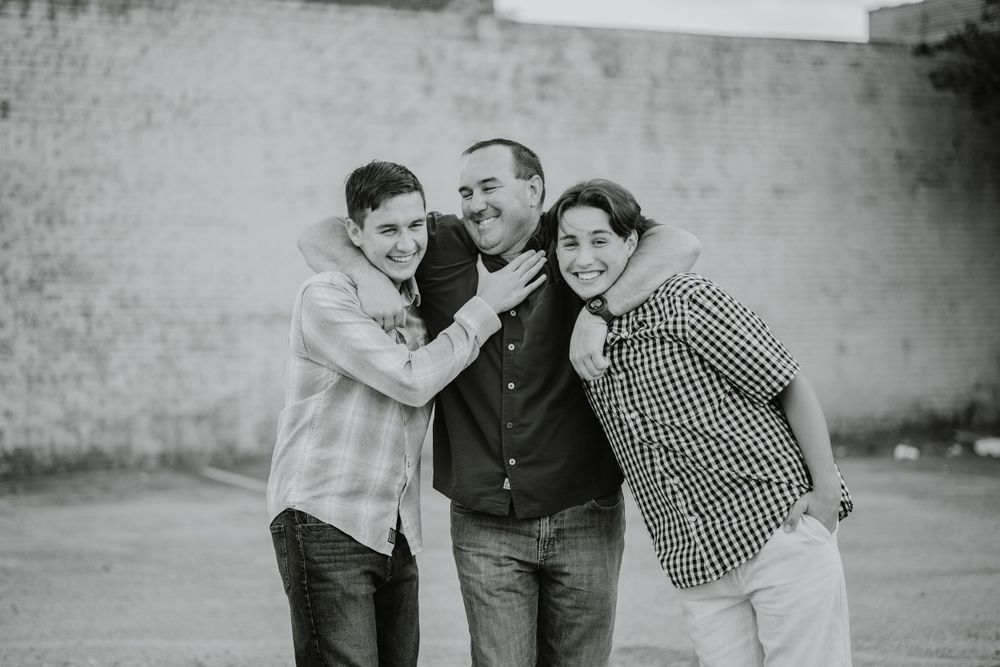 Black and white family portrait with vintage style showing natural interactions and laughter.