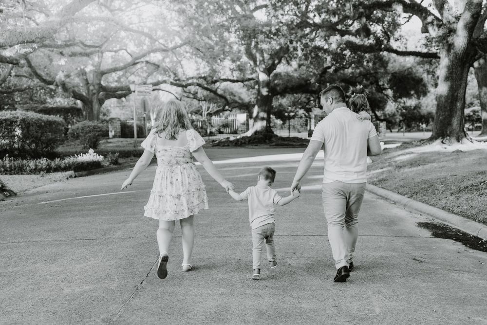 Black and white image of people walking on a garden path.