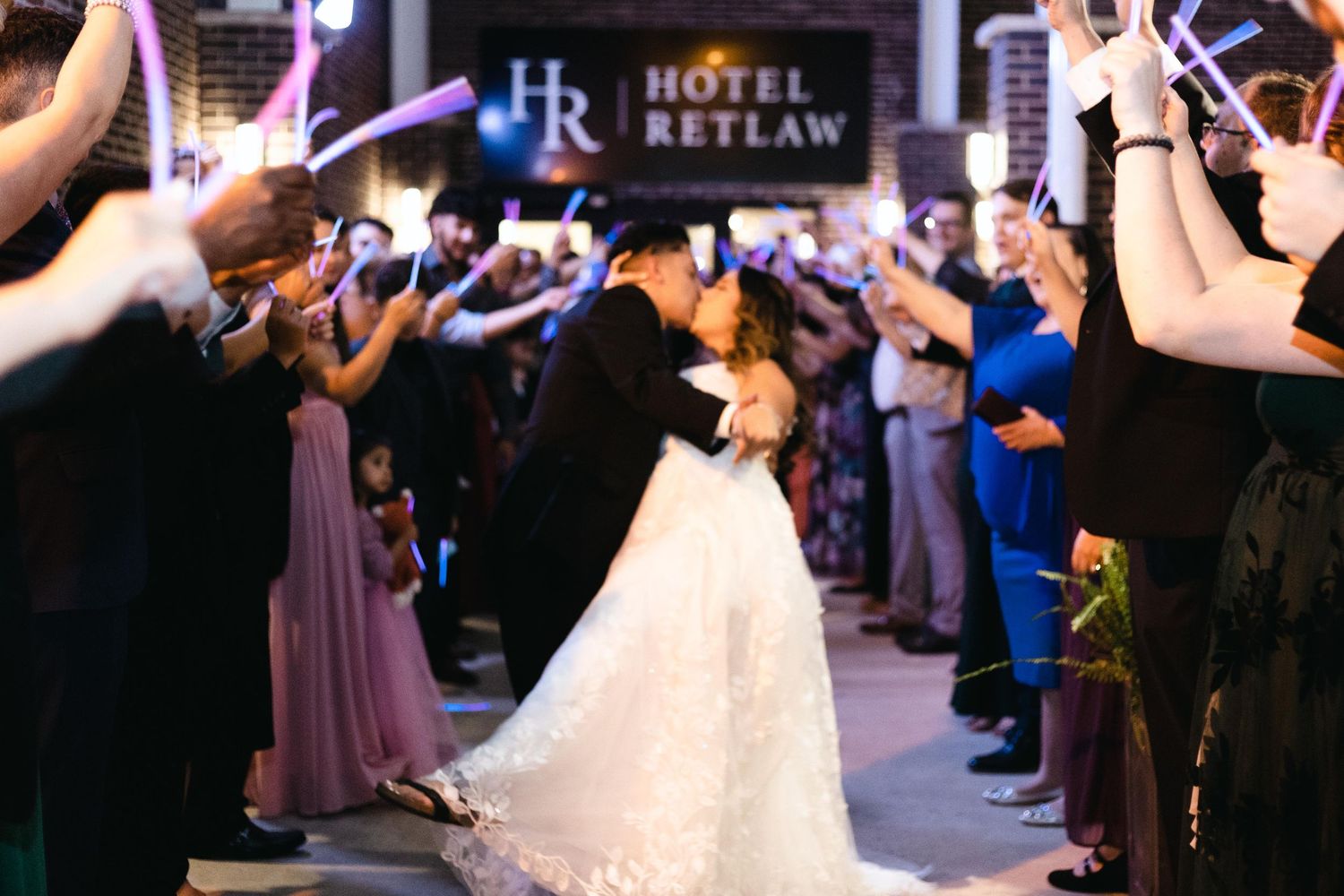 Wedding couple sharing a kiss during their sparkler exit at night outside Hotel Retlaw.